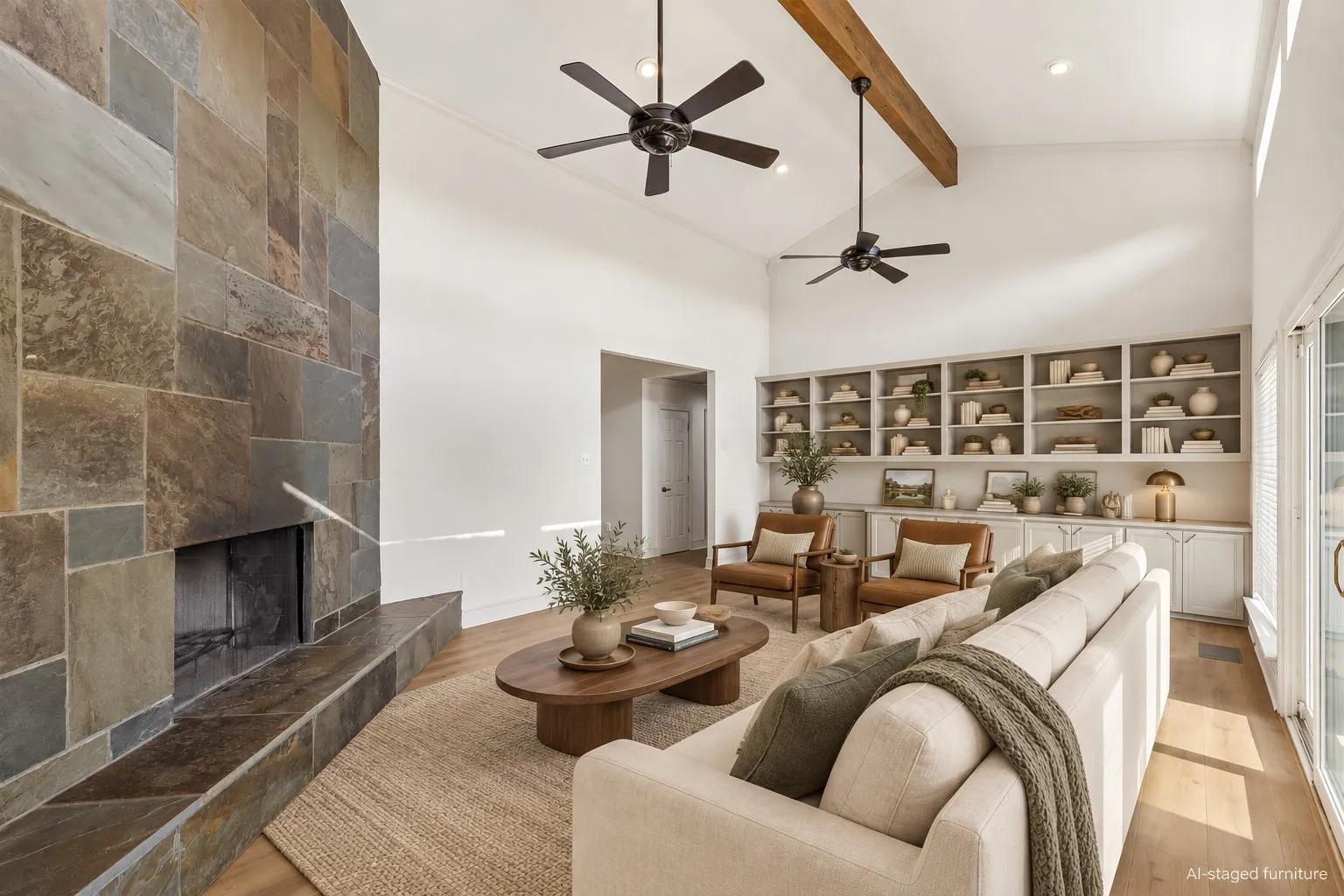 Vaulted ceiling with exposed wood beam, full-height stone fireplace, built-in shelving and cabinetry, recessed lighting, and wood-finish flooring