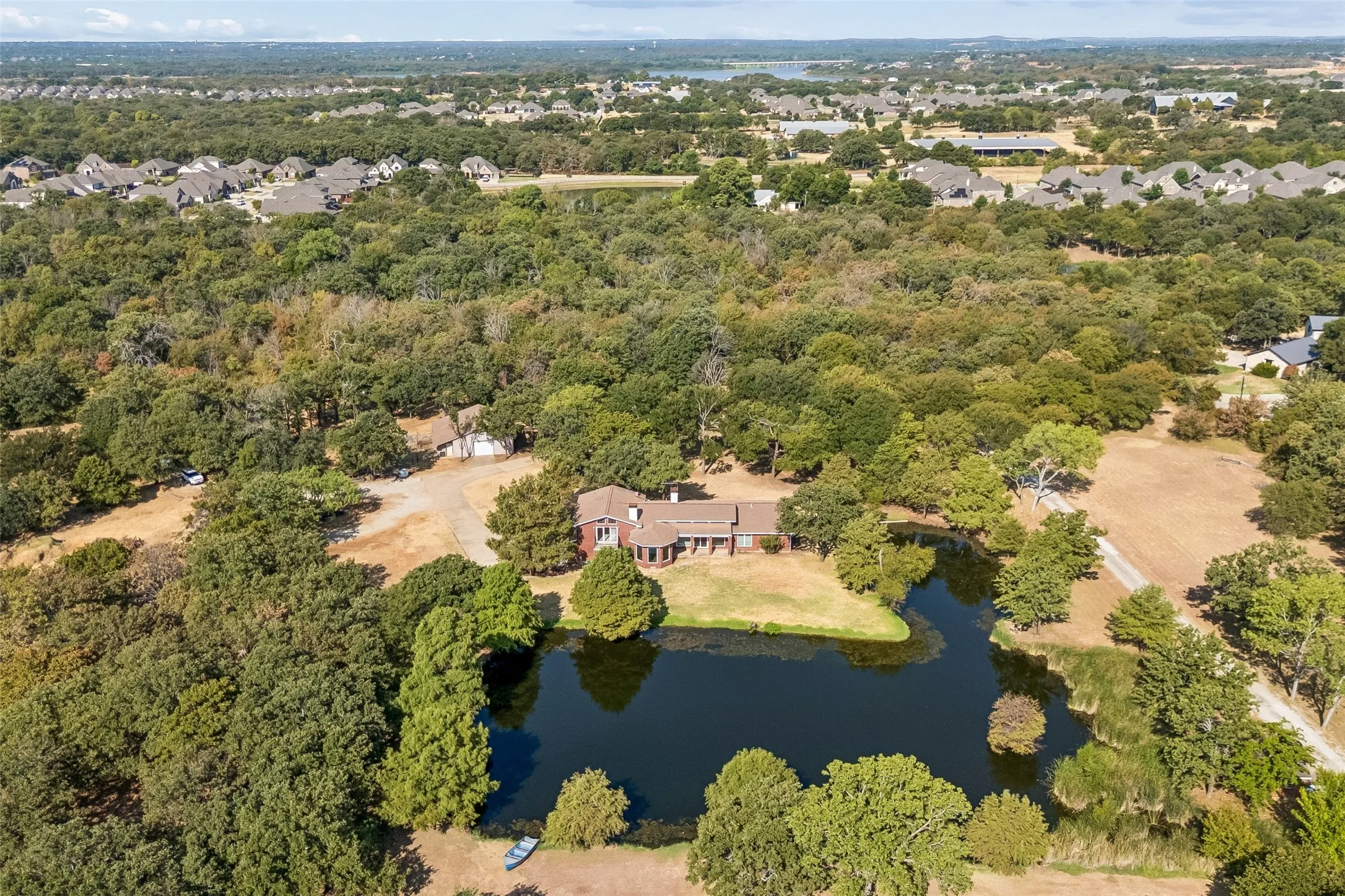 Expansive property featuring a private pond, abundant mature trees, and a secluded residence