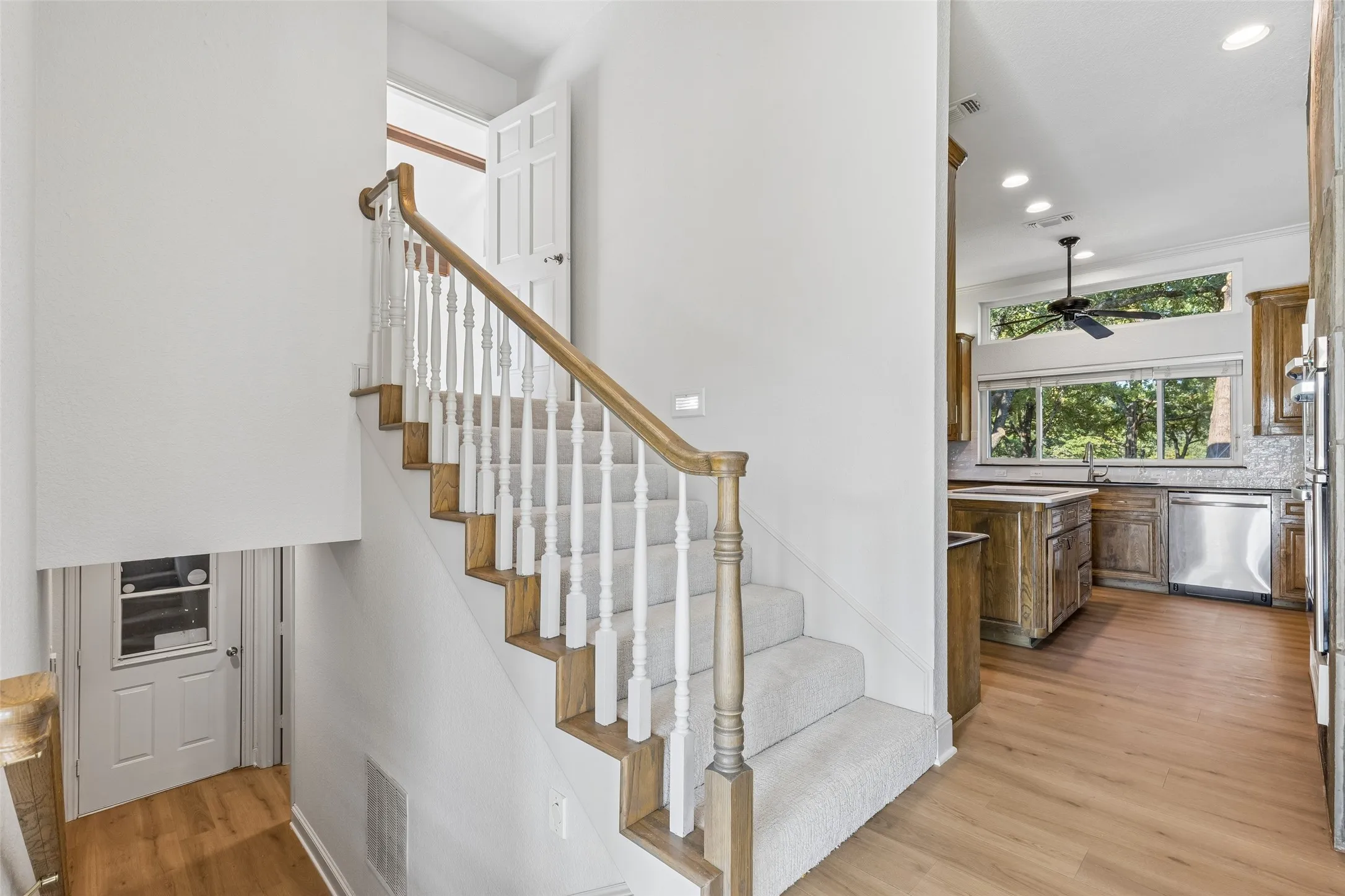 Staircase with carpeted treads, wood-finish risers, and a wood handrail