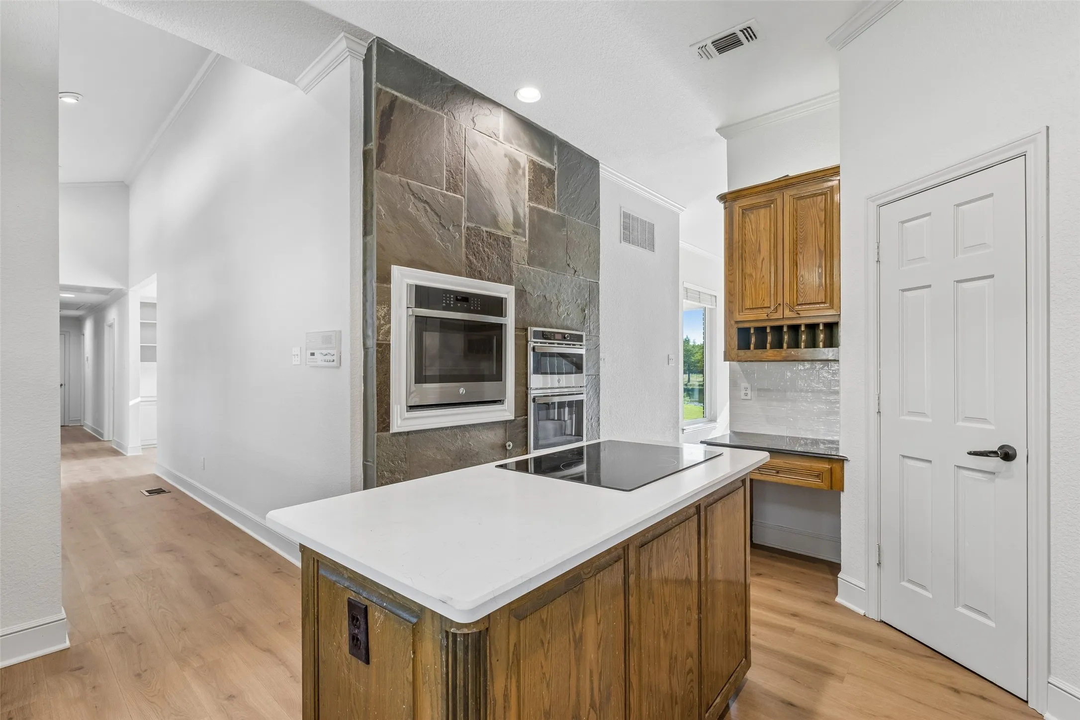 Kitchen island with a light-toned countertop and integrated cooktop