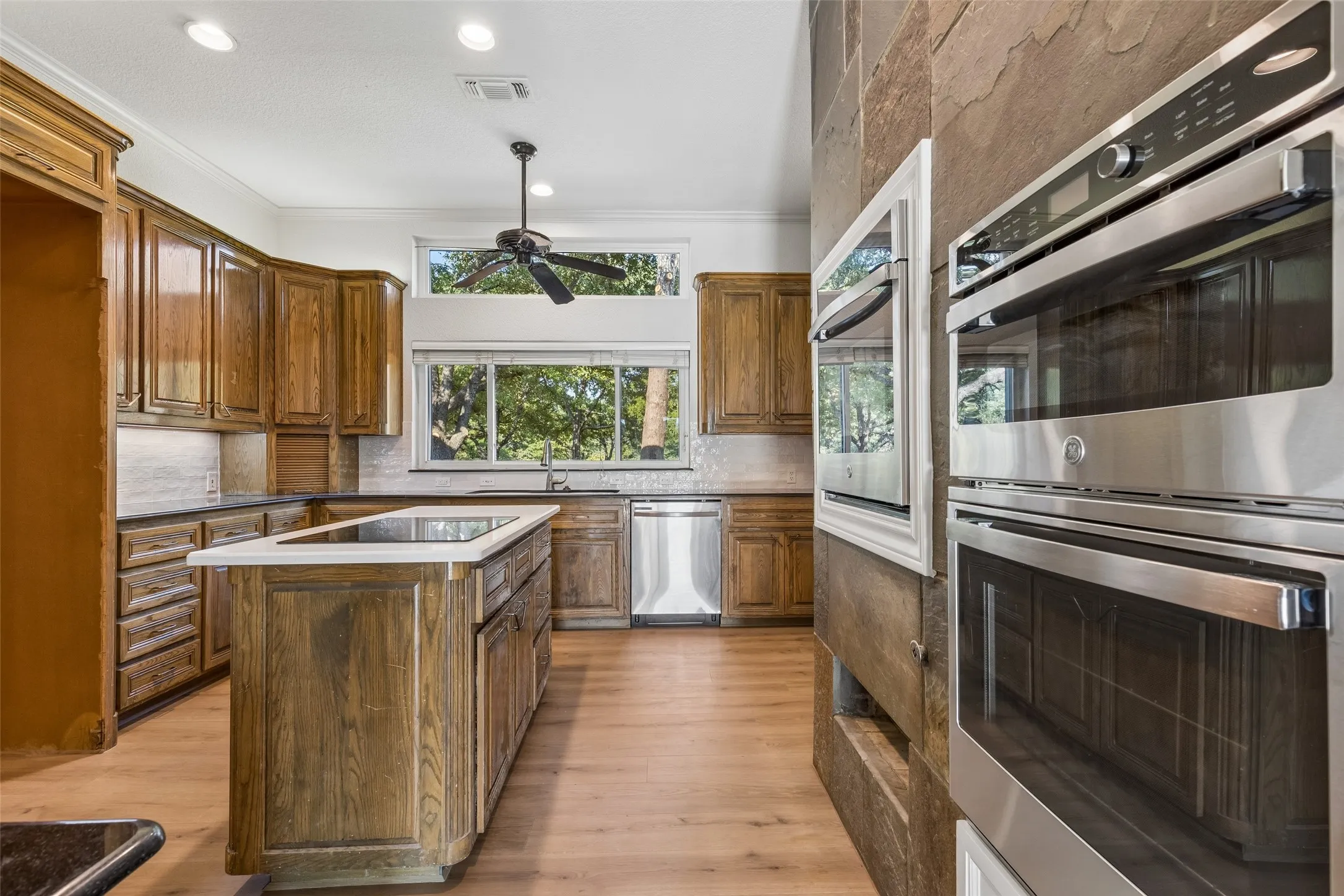 Kitchen featuring wood-finish flooring, recessed lighting, and a kitchen island with a cooktop
