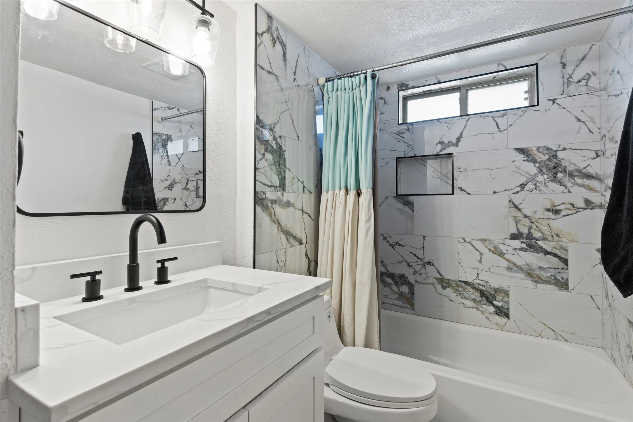 Vanity with an integrated sink, matte black faucet, and white countertop