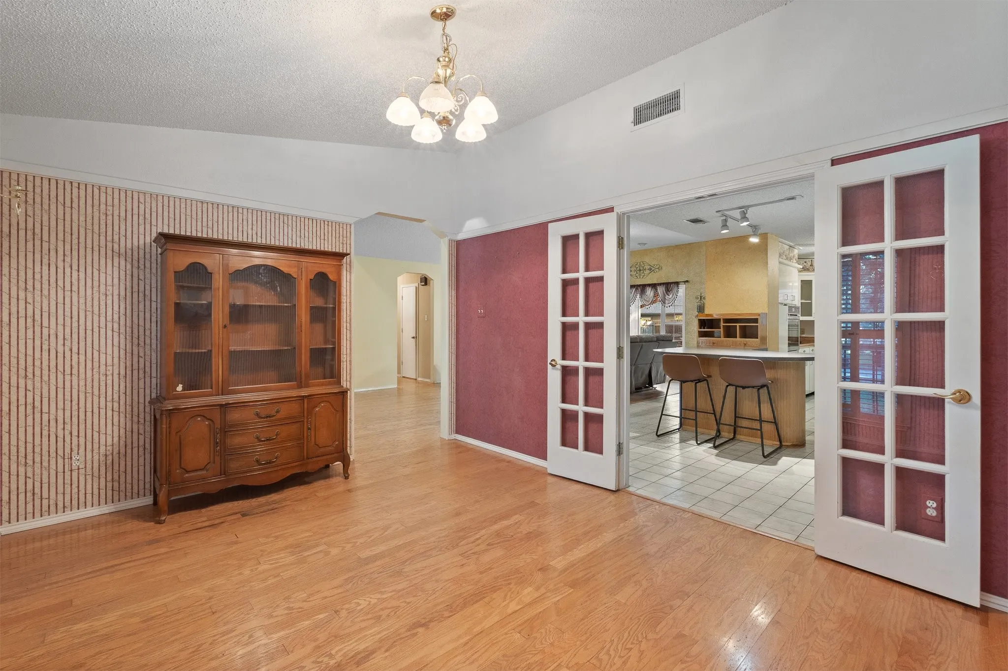 Wood-finish flooring throughout, with a decorative chandelier and vaulted ceiling