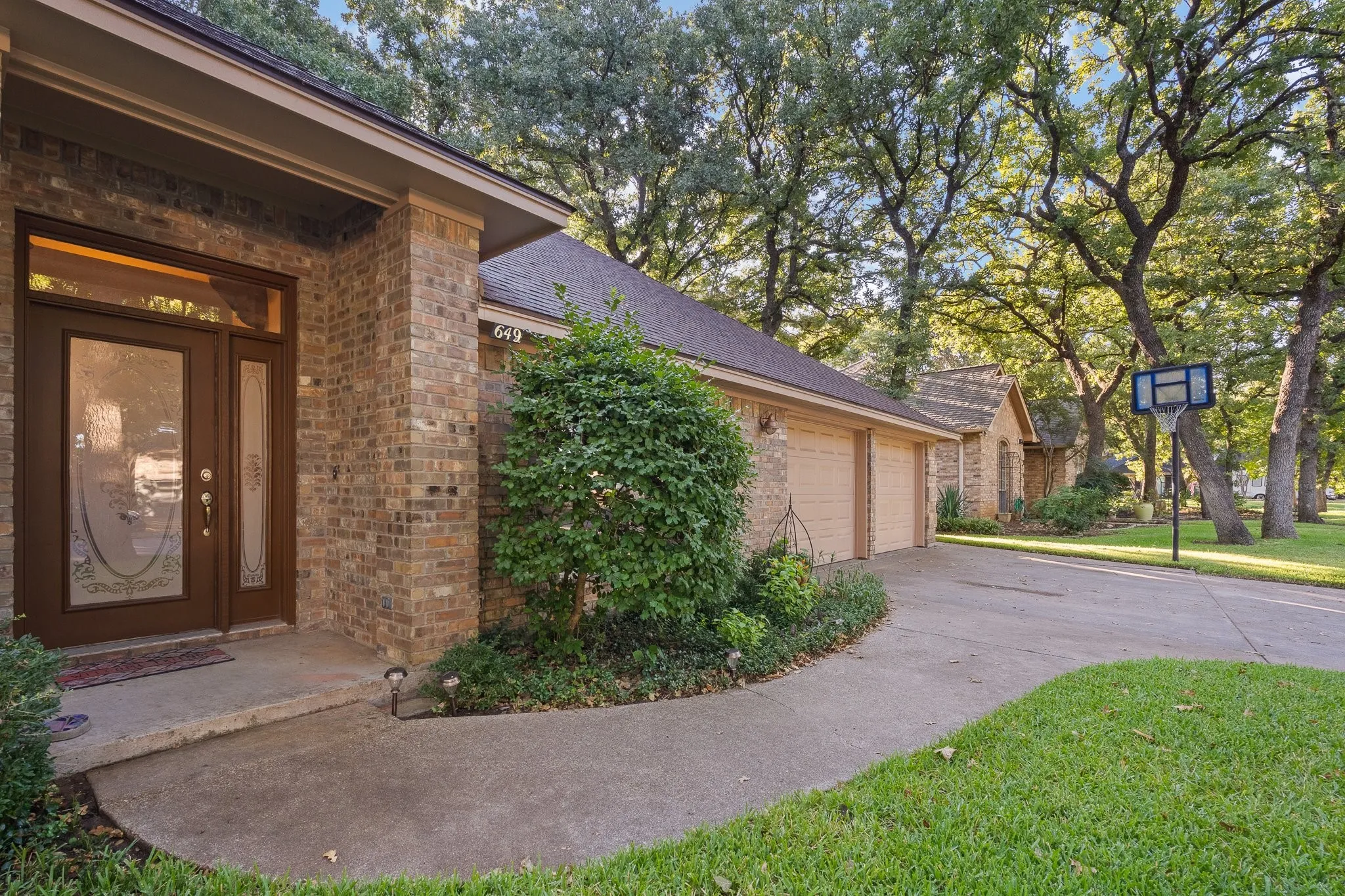 Brick exterior with a prominent front entry, featuring a double door with decorative glass inserts and a transom window