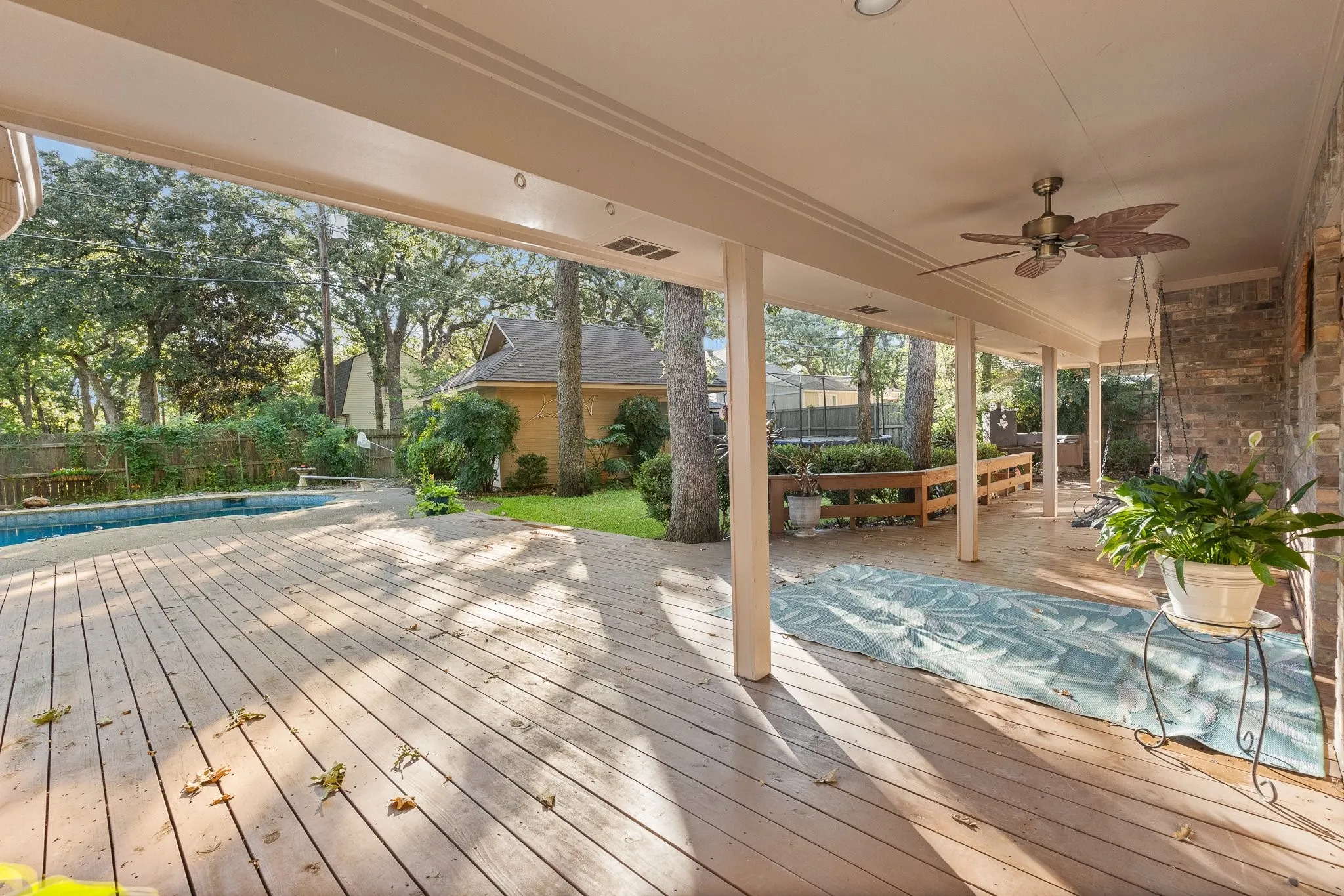 Expansive covered wood-finish deck with recessed lighting and a ceiling fan