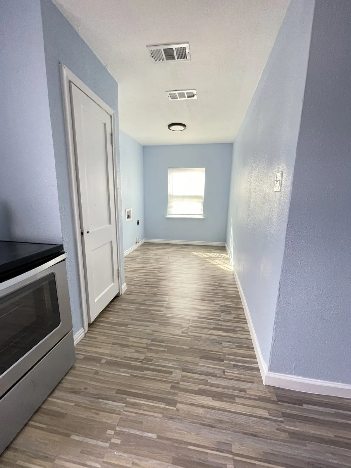 Corridor featuring dark wood-type flooring and a textured wall