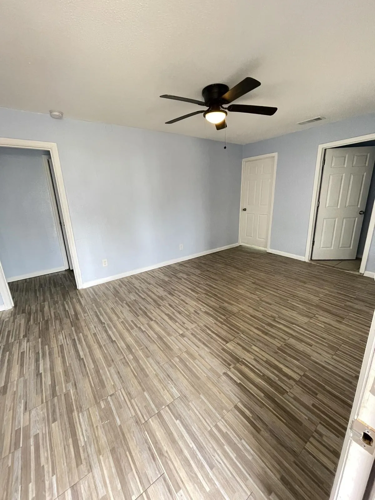 Unfurnished bedroom with a ceiling fan, wood finished floors, and a closet