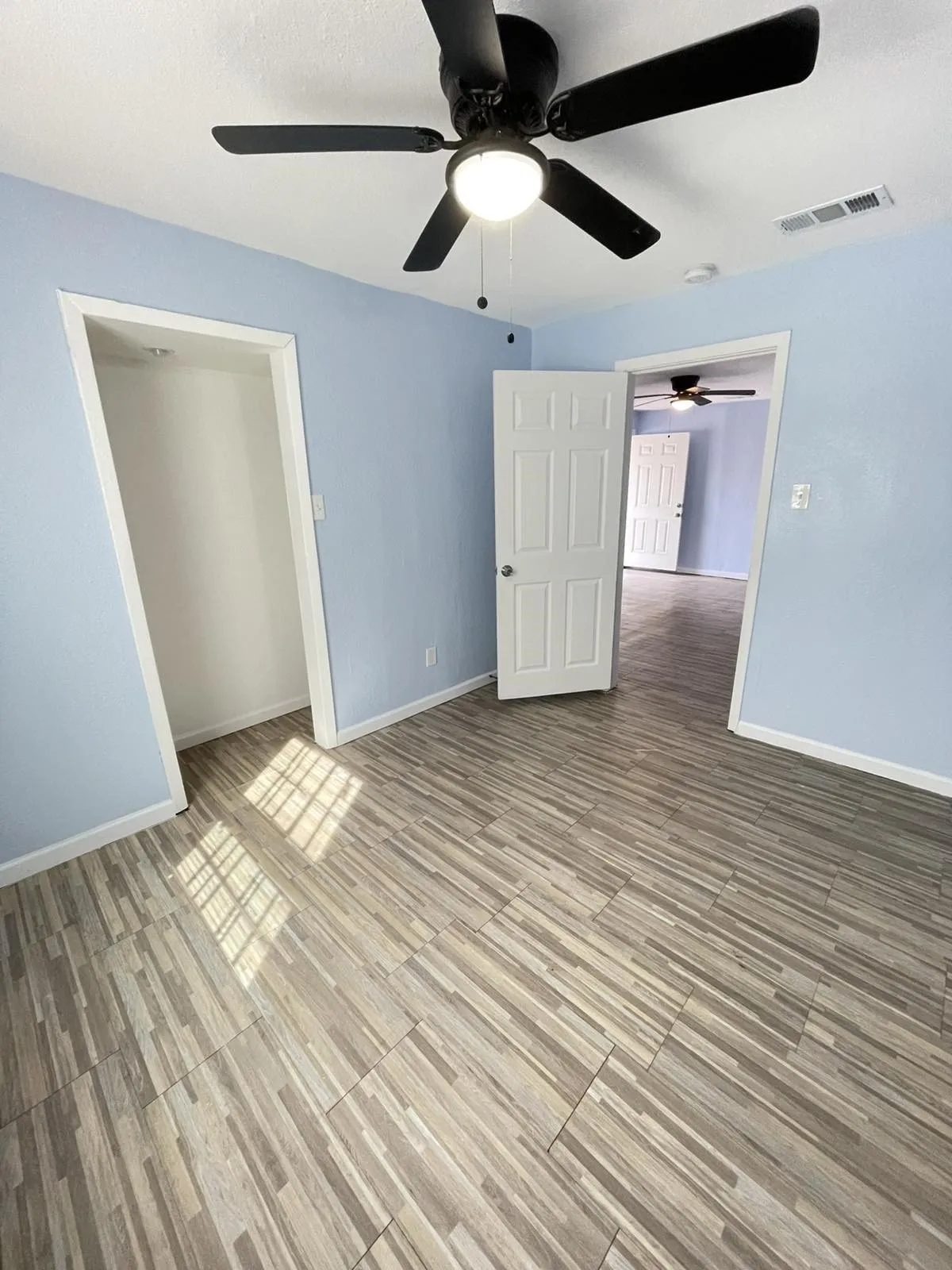 Unfurnished bedroom featuring a ceiling fan, light wood-style flooring, and a closet