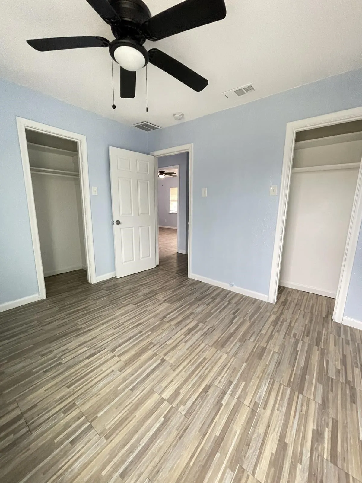 Unfurnished bedroom with a ceiling fan and light wood-style flooring