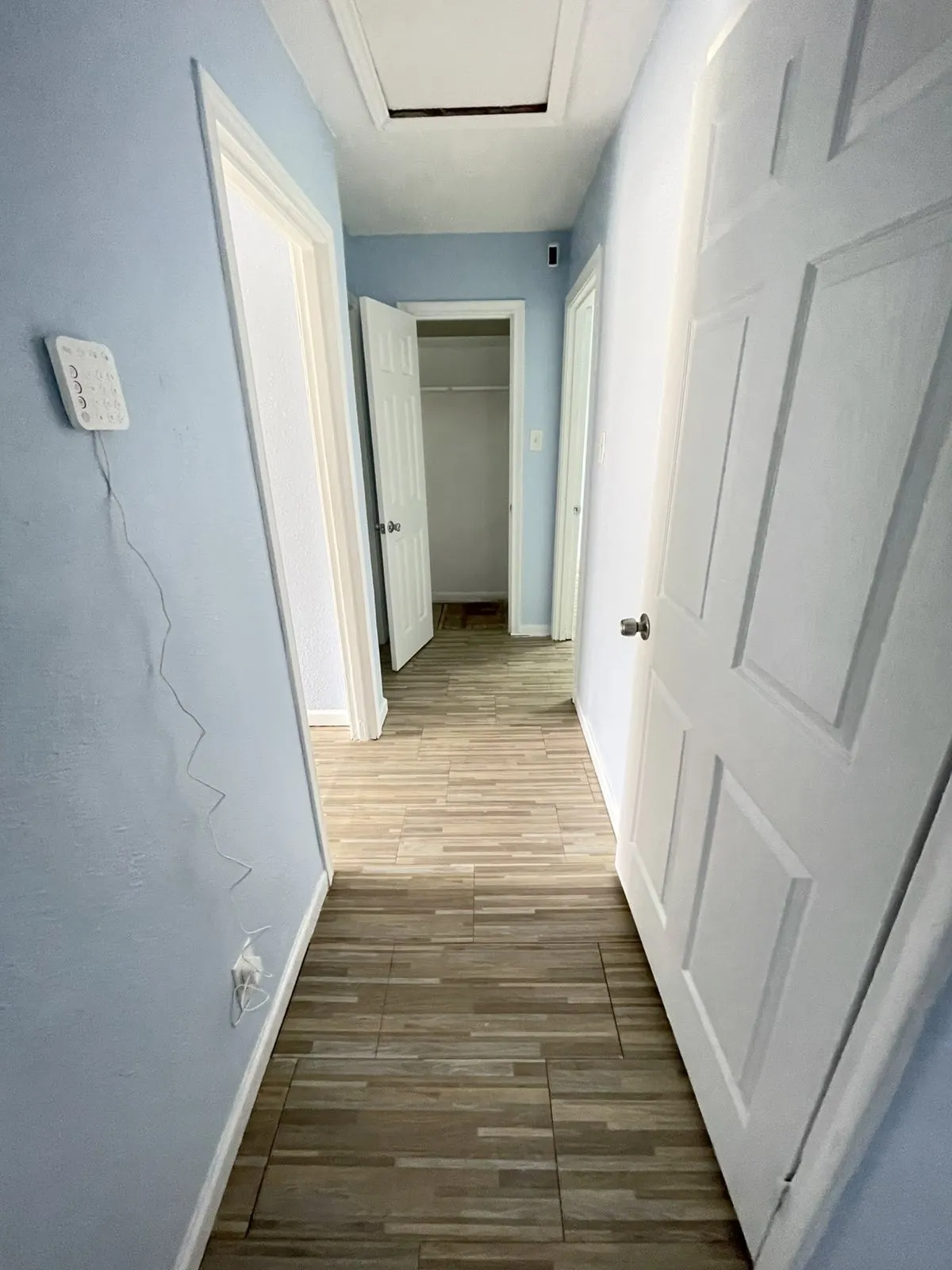 Hallway featuring light wood finished floors and baseboards