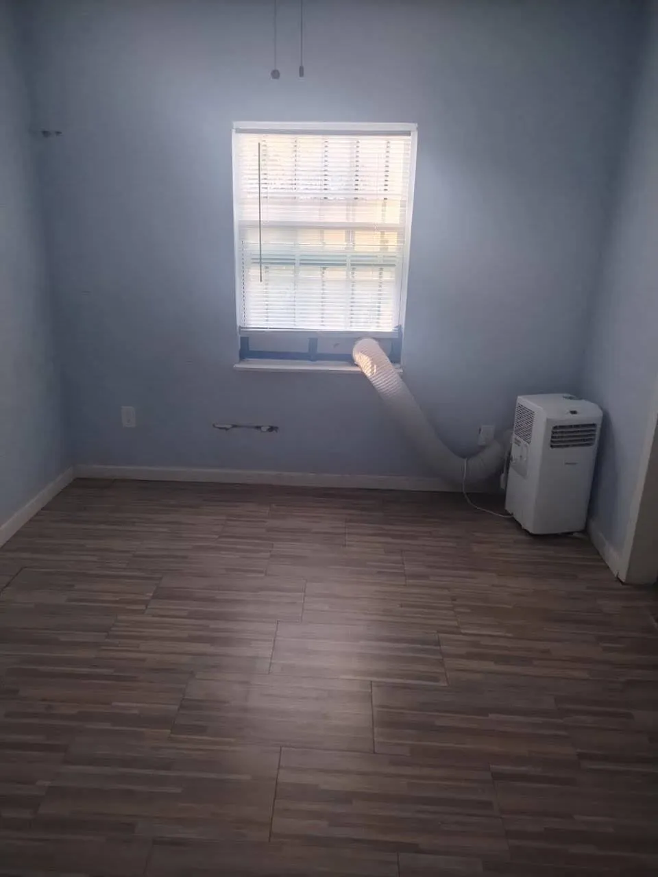Empty room with baseboards and dark wood-type flooring