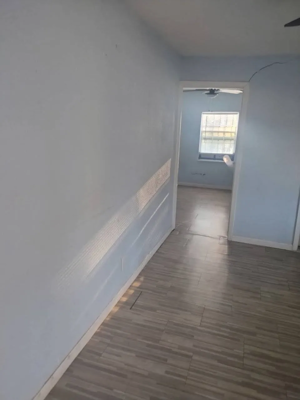 Corridor featuring baseboards and dark wood-style floors