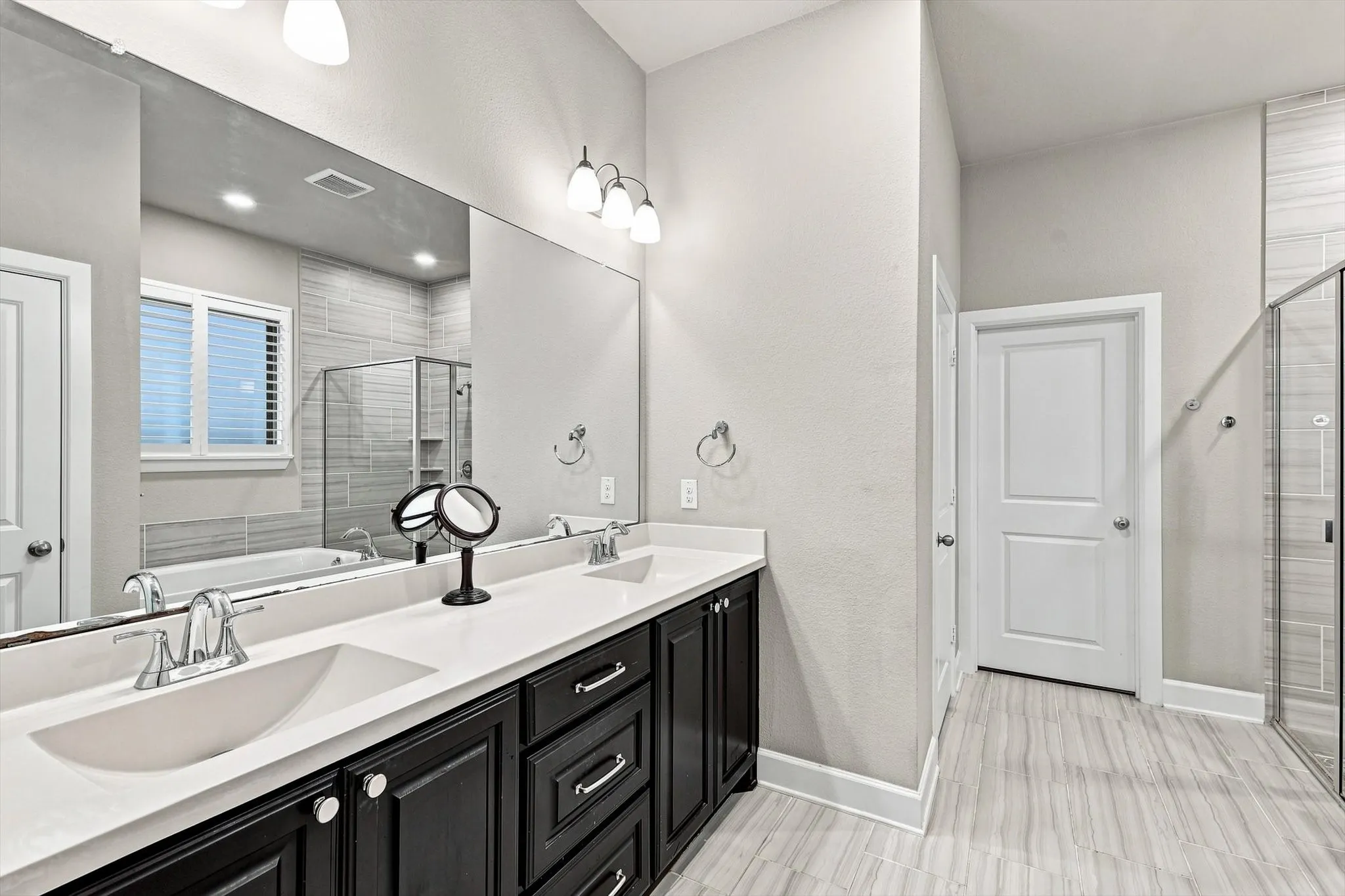 Dual vanity with dark wood cabinetry, white countertops, and undermount sinks