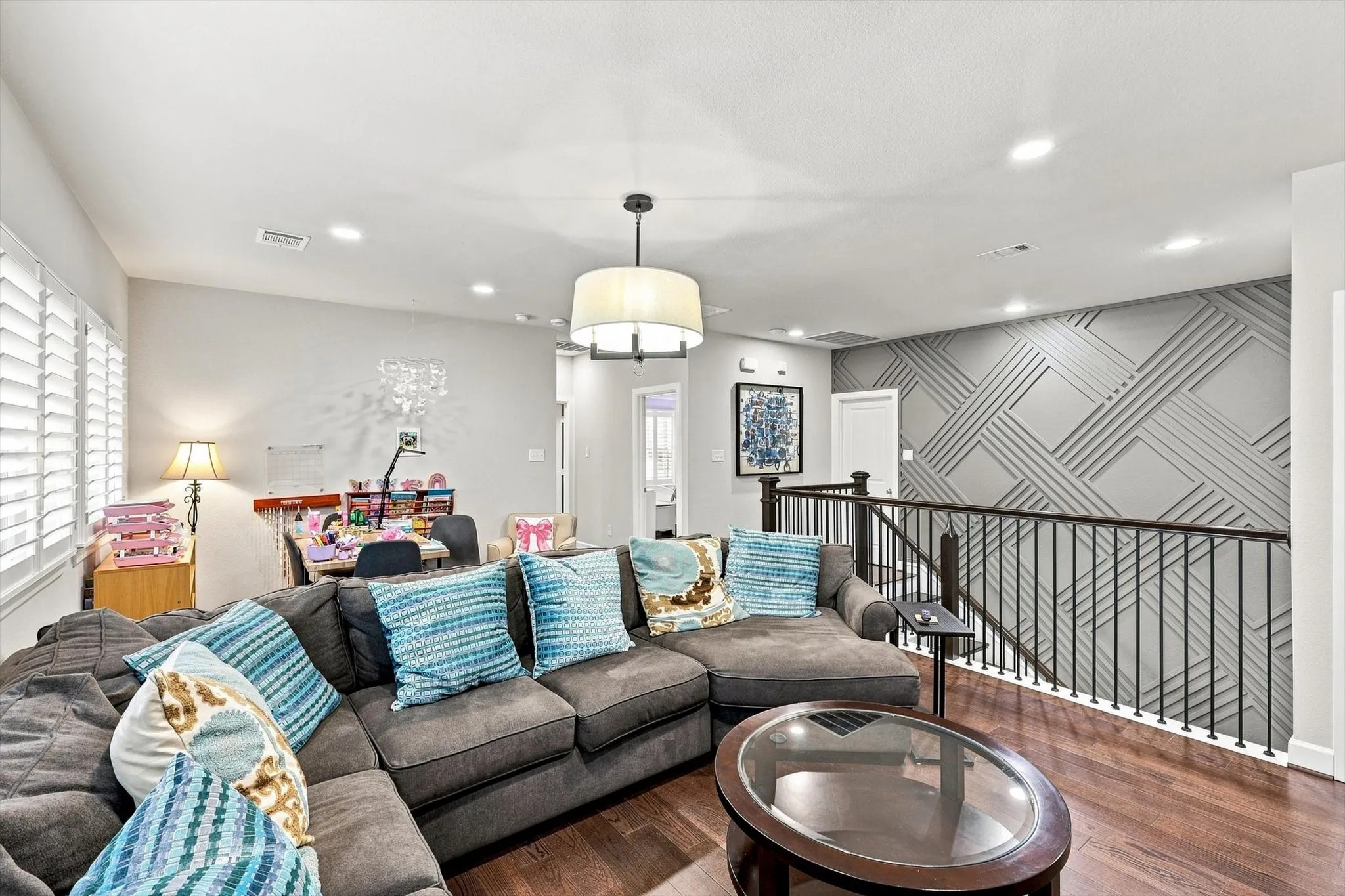 Hardwood-finish flooring, recessed lighting, and a decorative accent wall featuring geometric paneling