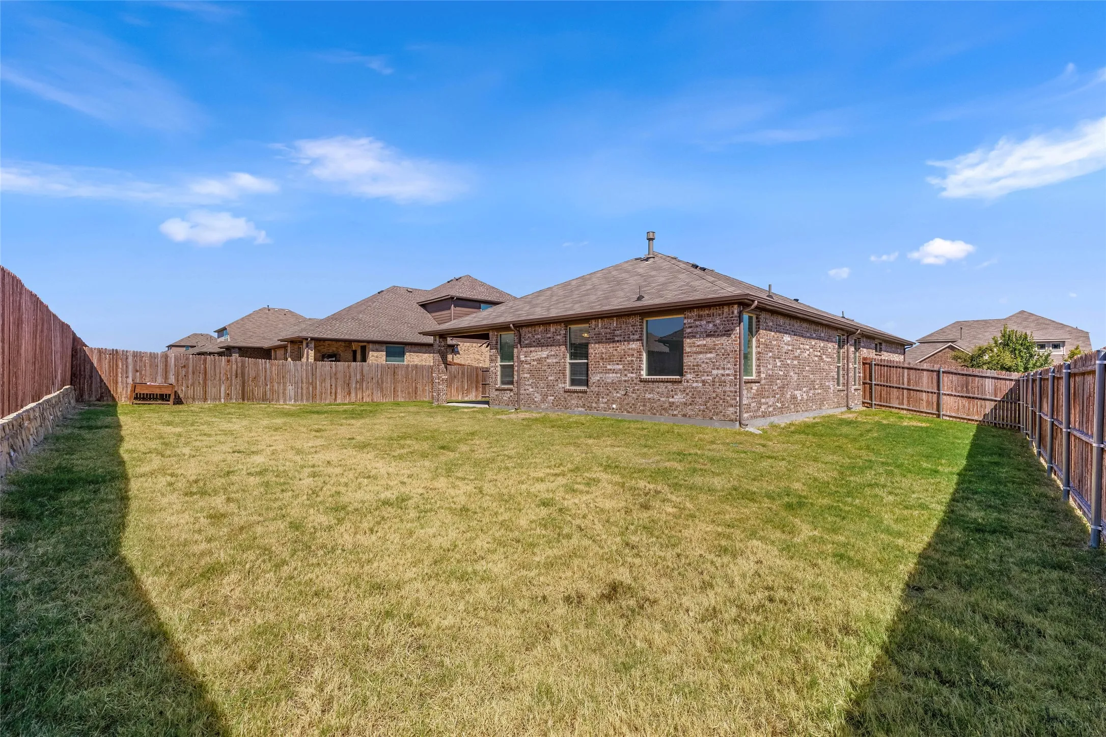 Expansive lawn area enclosed by wood fencing