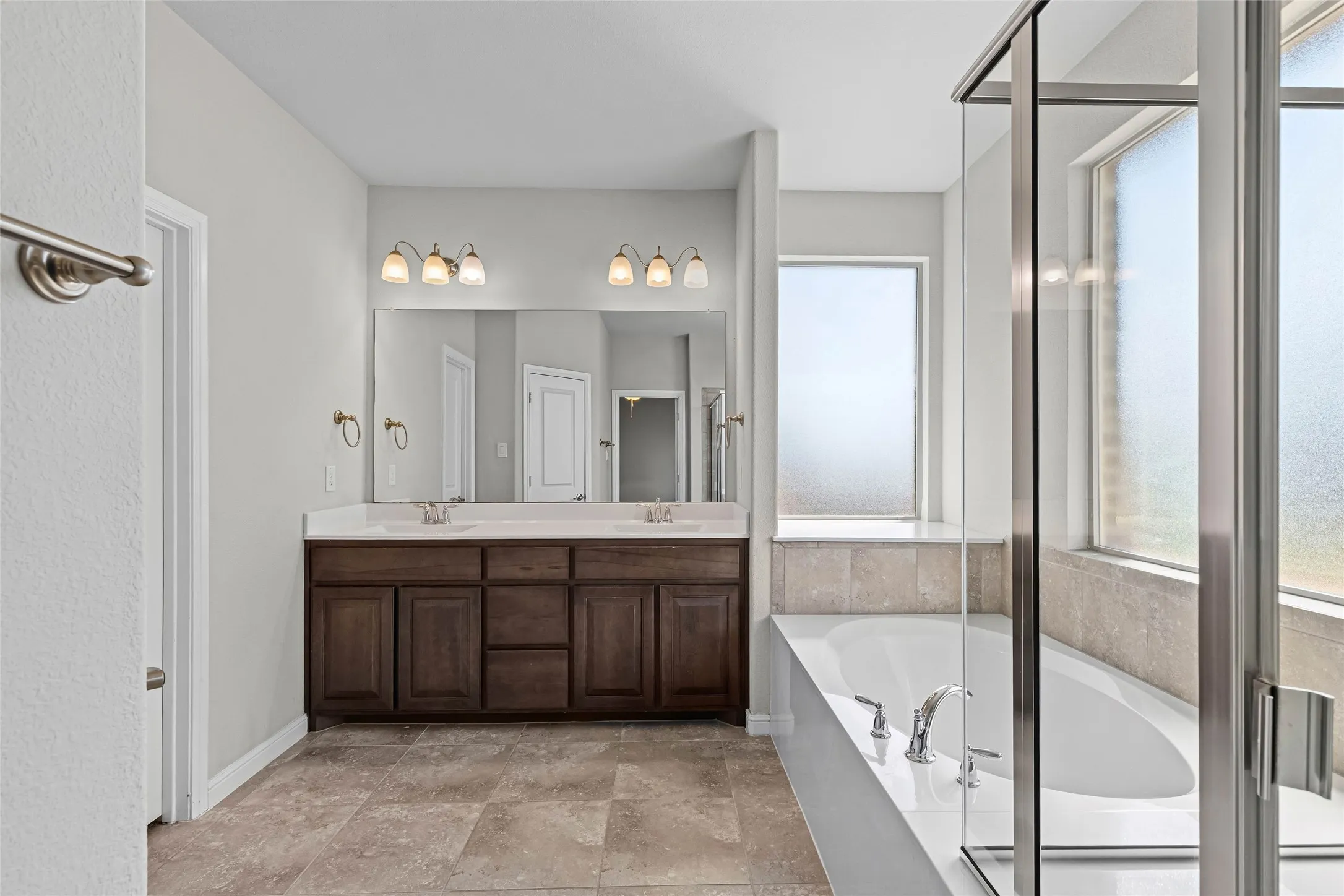 Dual vanity with dark wood-finish cabinetry and white countertops