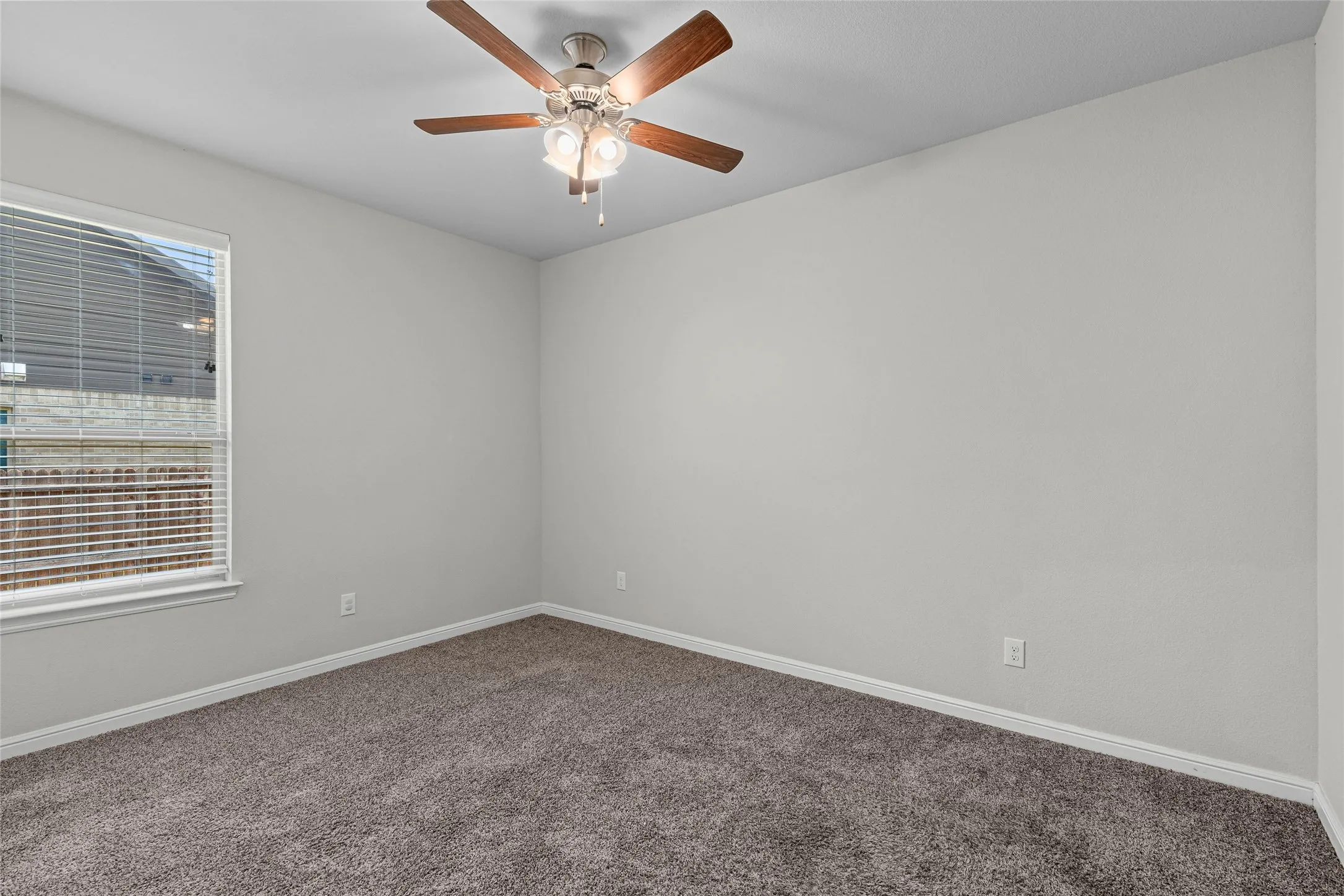 Window with blinds, wood-finish ceiling fan with integrated lighting, neutral wall paint, and carpet flooring