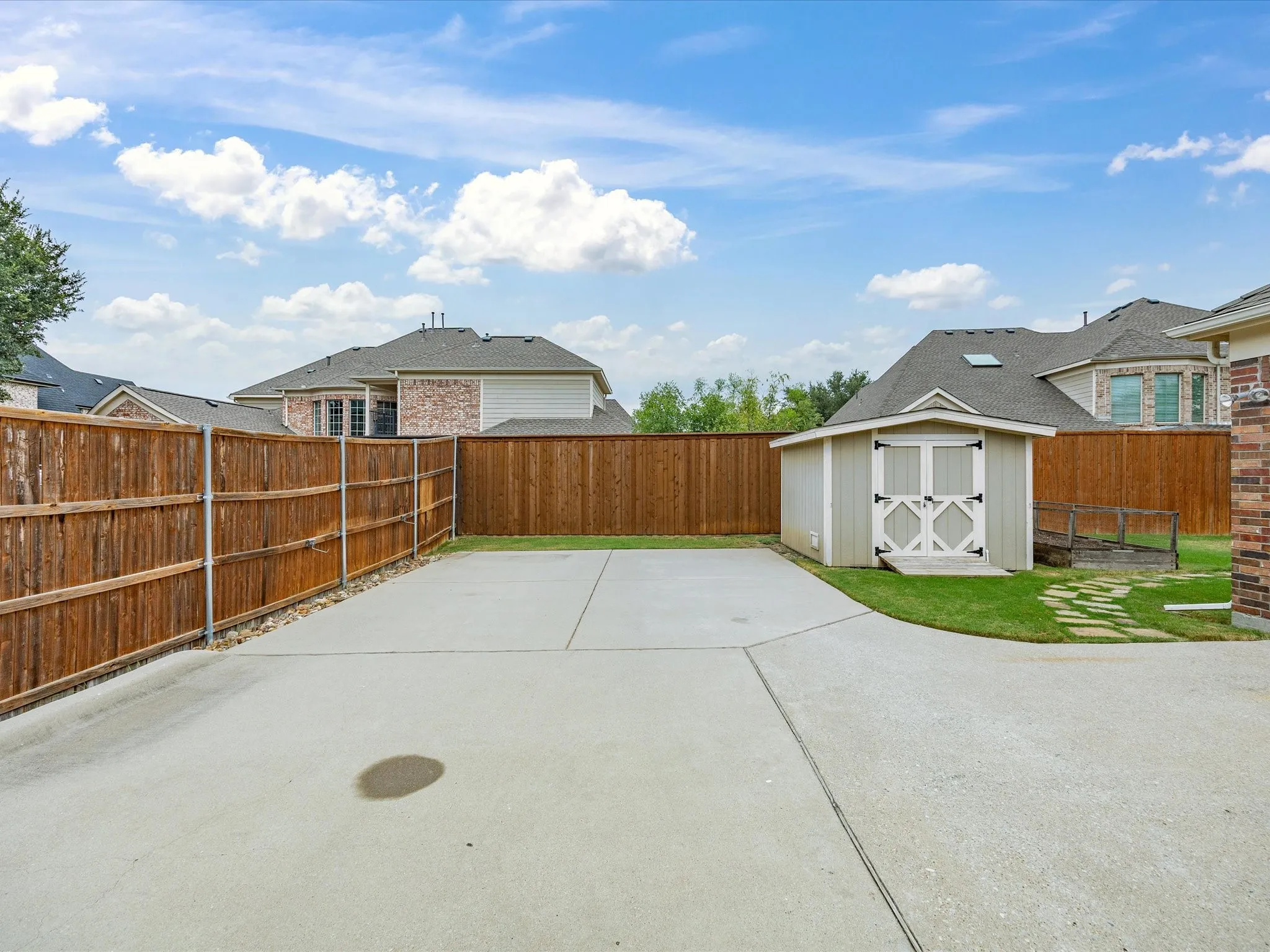 Shed with cement parking behind gate in backyard