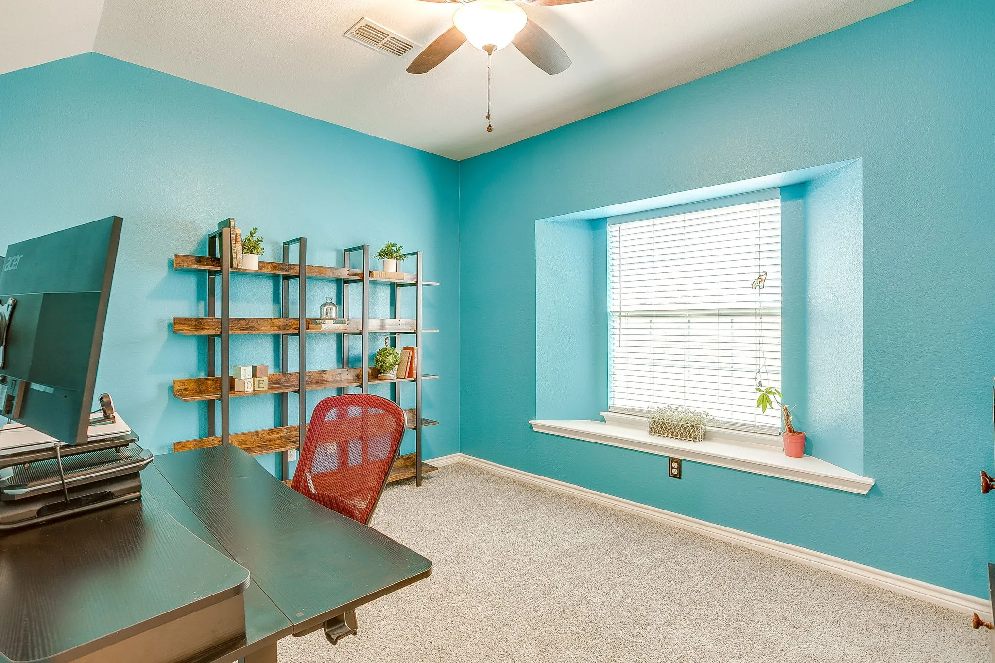 Recessed window with a deep sill, textured walls, ceiling fan, and carpeted flooring