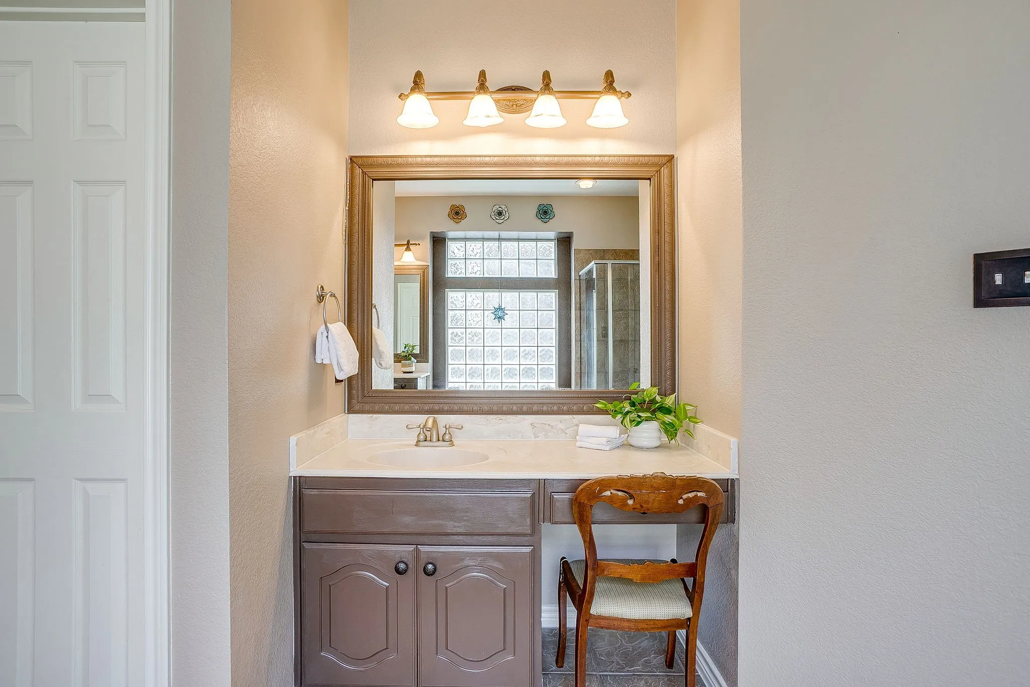 Vanity featuring a built-in sink, framed mirror, and a wall-mounted light fixture