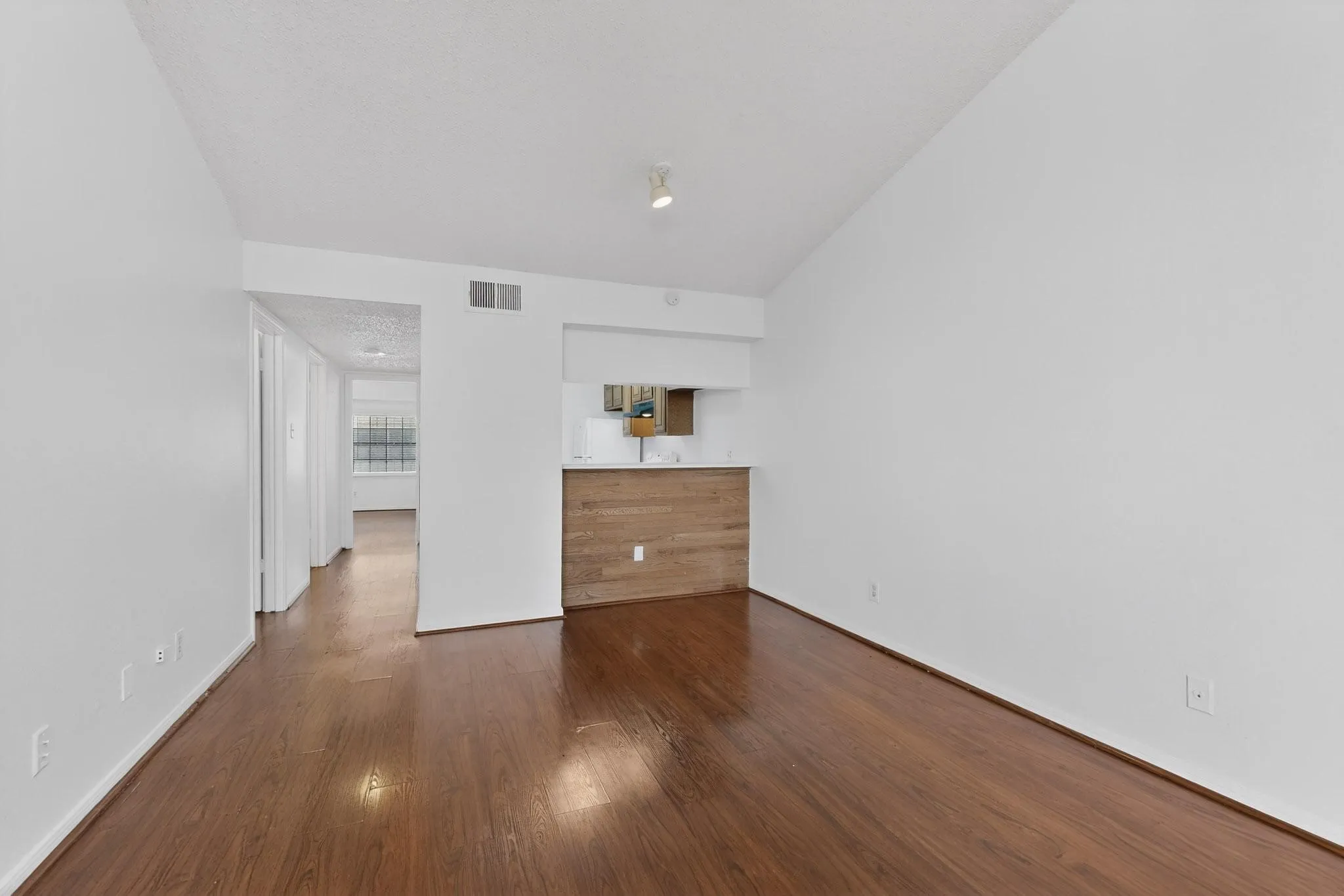 Unfurnished bedroom featuring dark wood-style floors and lofted ceiling