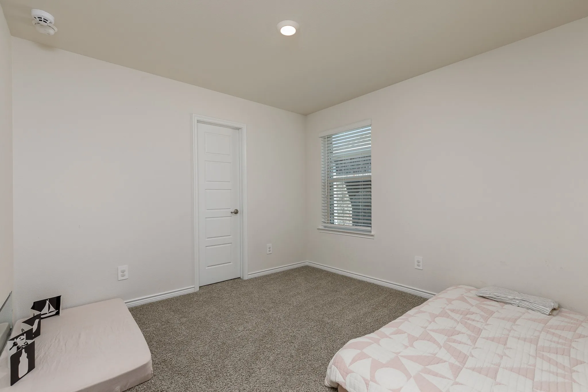 Neutral wall color, recessed lighting, window with blinds, paneled interior door, and carpeted flooring