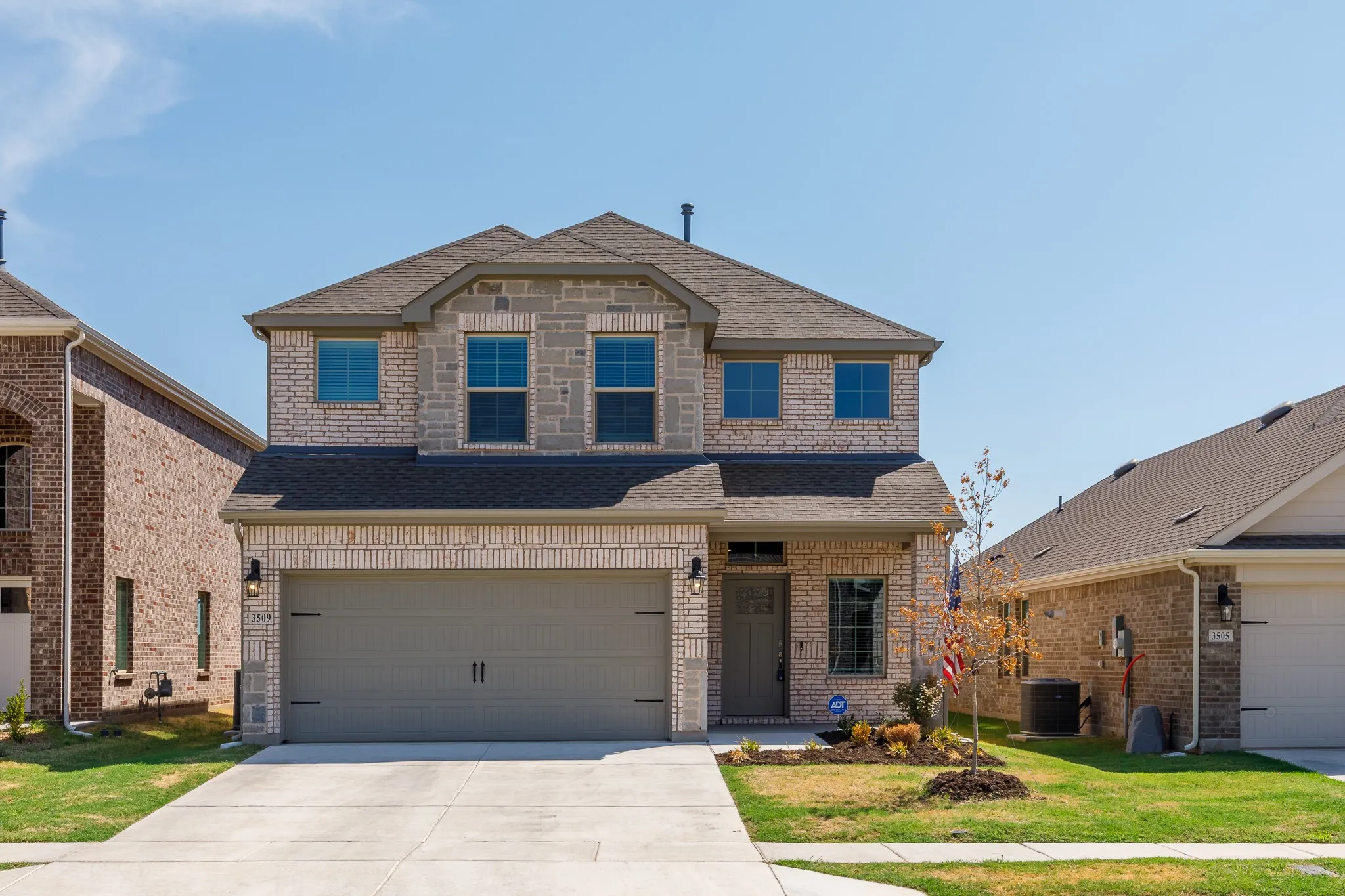 Two-story brick and stone exterior with an attached two-car garage
