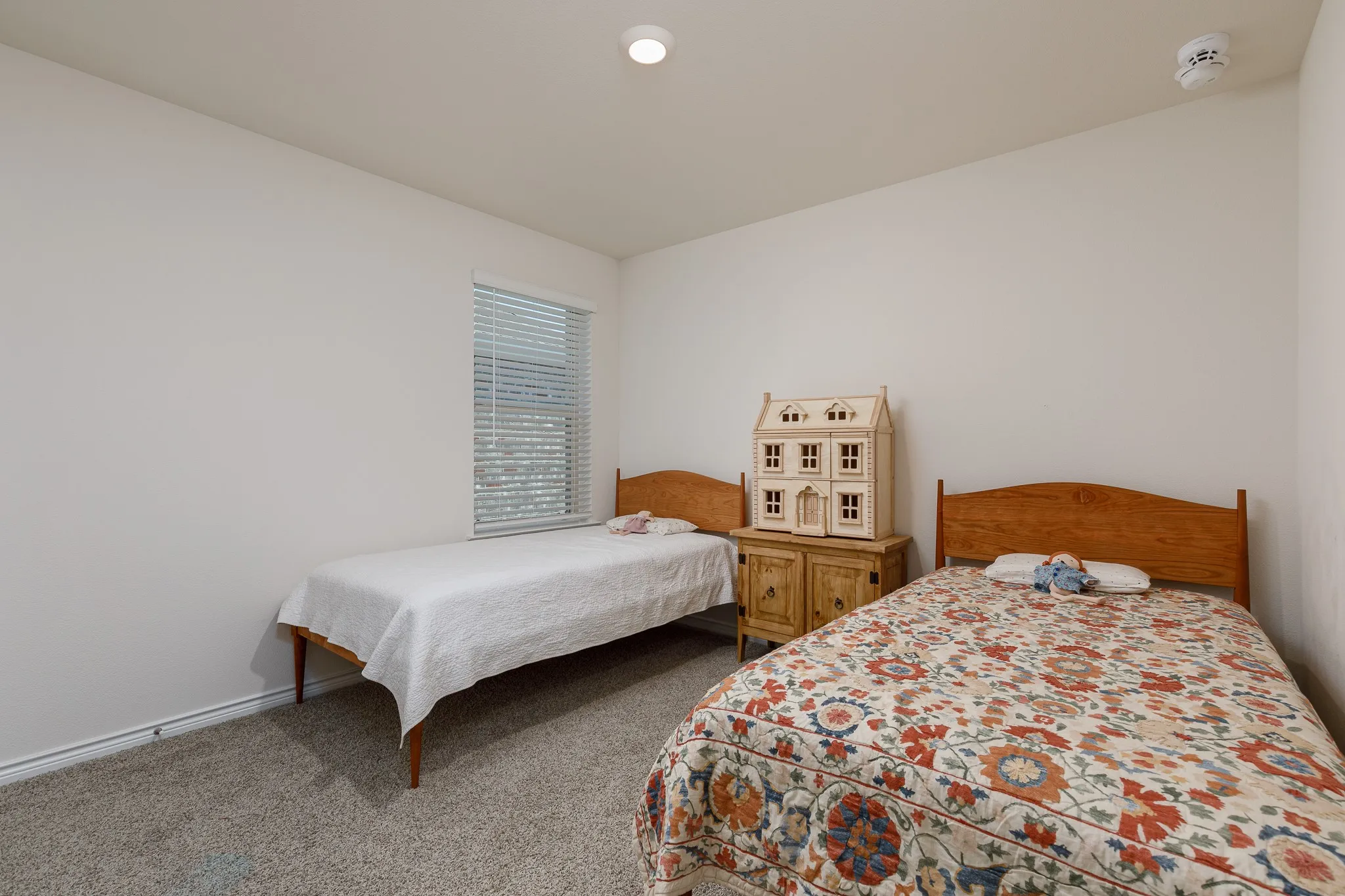 Carpeted flooring, recessed ceiling lighting, single window with horizontal blinds, and neutral wall tones