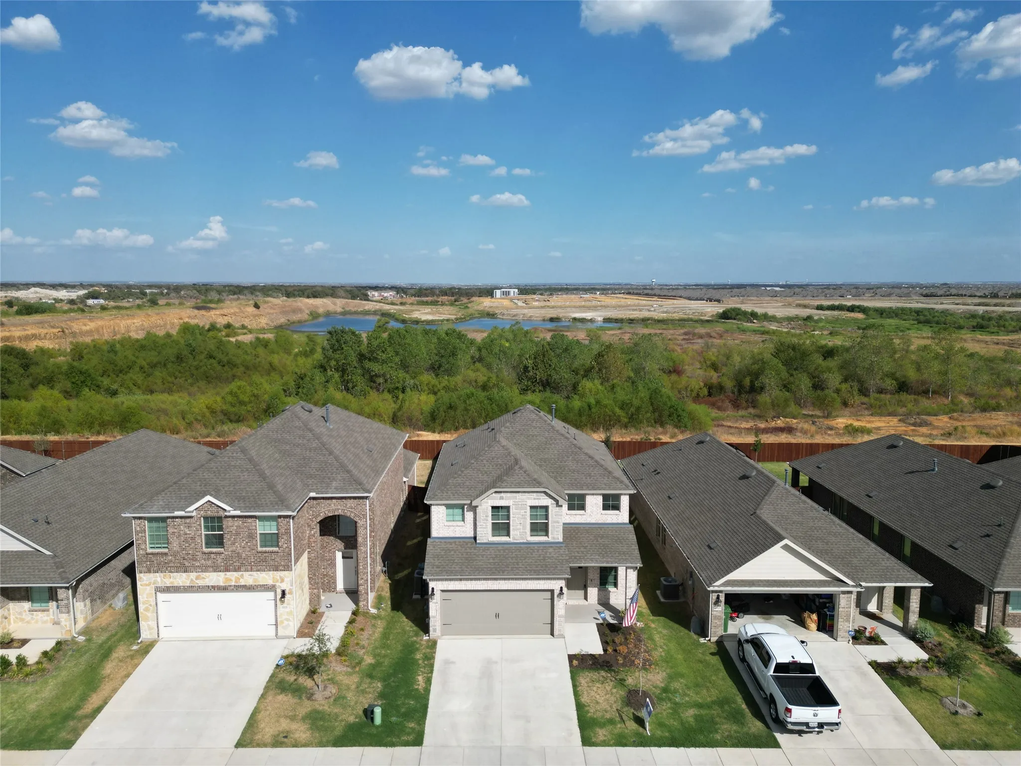 Two-story residence with a light-colored brick facade, a two-car garage, and a concrete driveway
