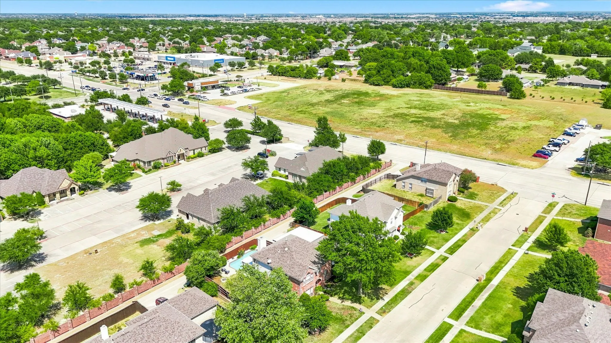 Aerial perspective showcasing a residential neighborhood with surrounding commercial developments and open green spaces
