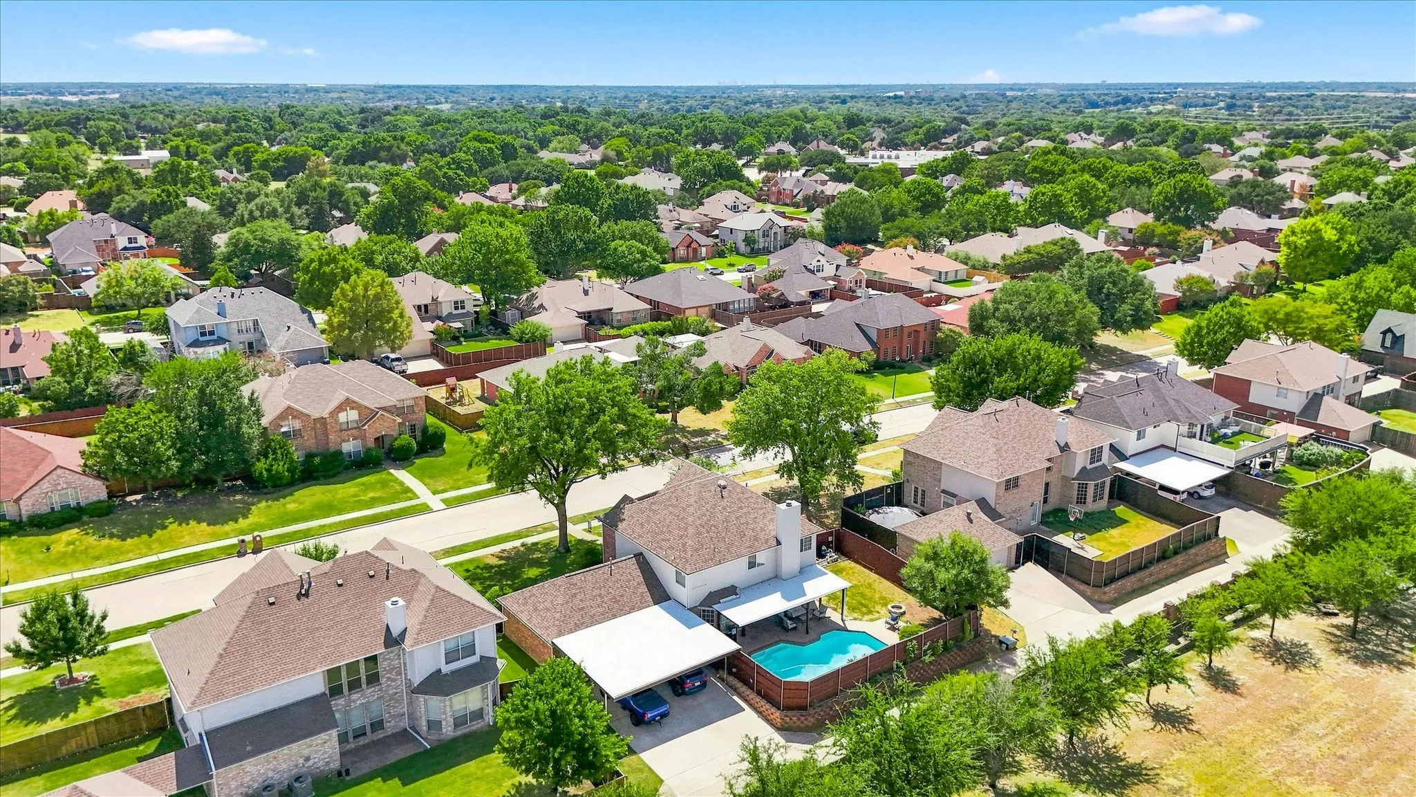 Residential neighborhood featuring mature trees, diverse architectural styles, and private swimming pools