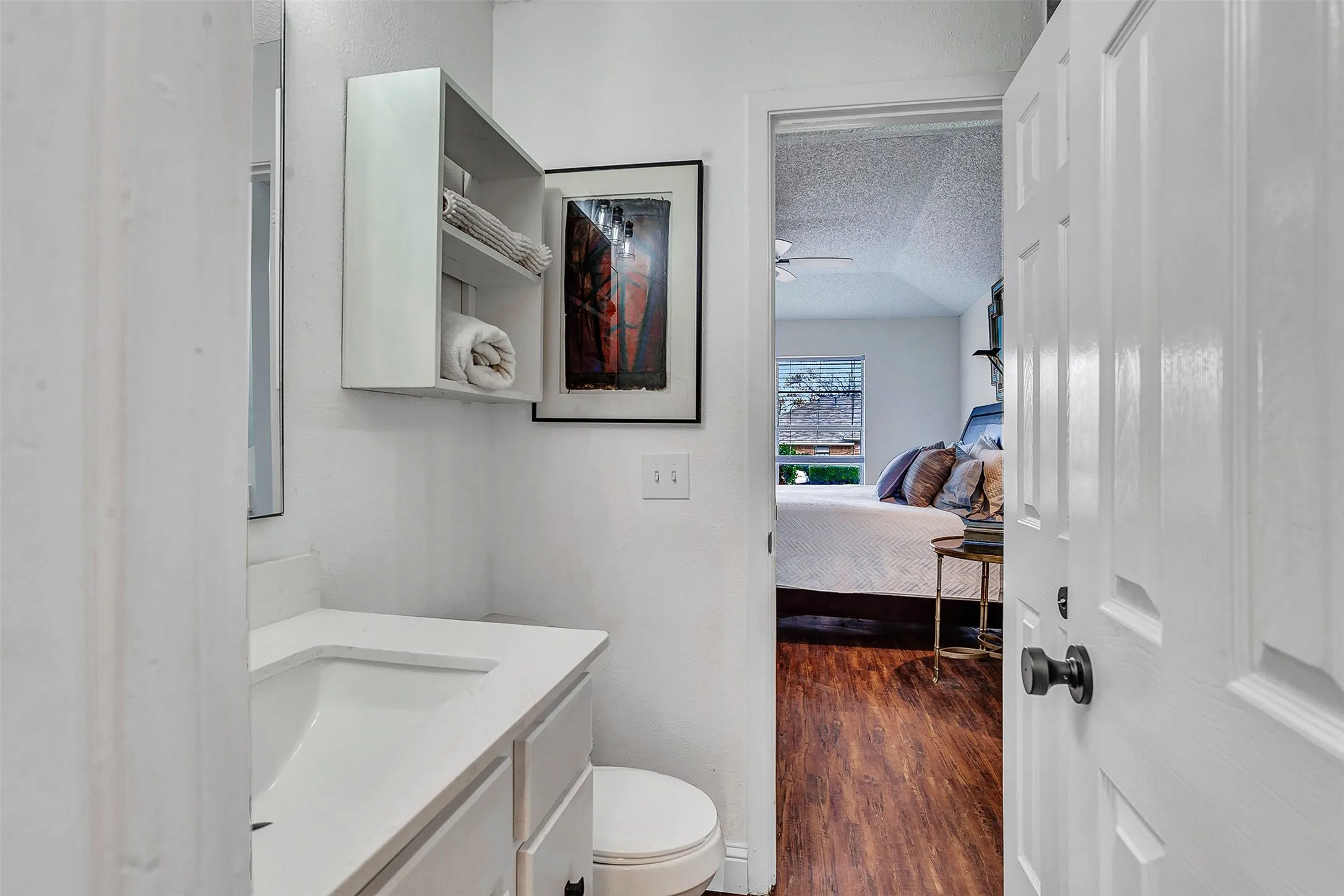 White vanity with an integrated sink and storage cabinetry