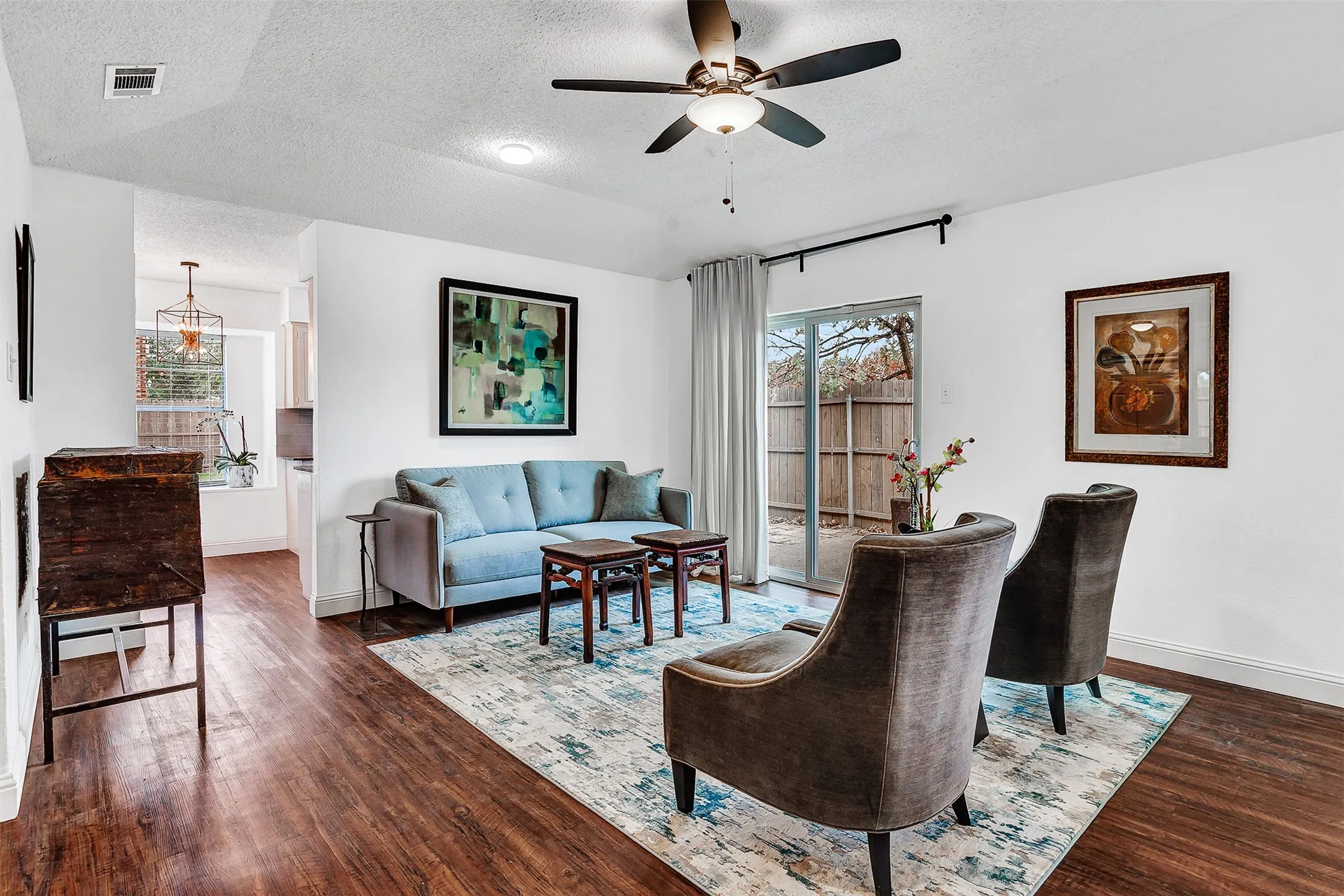 Hardwood-finish flooring throughout, ceiling fan with integrated lighting, recessed lighting, and sliding glass door access to the exterior