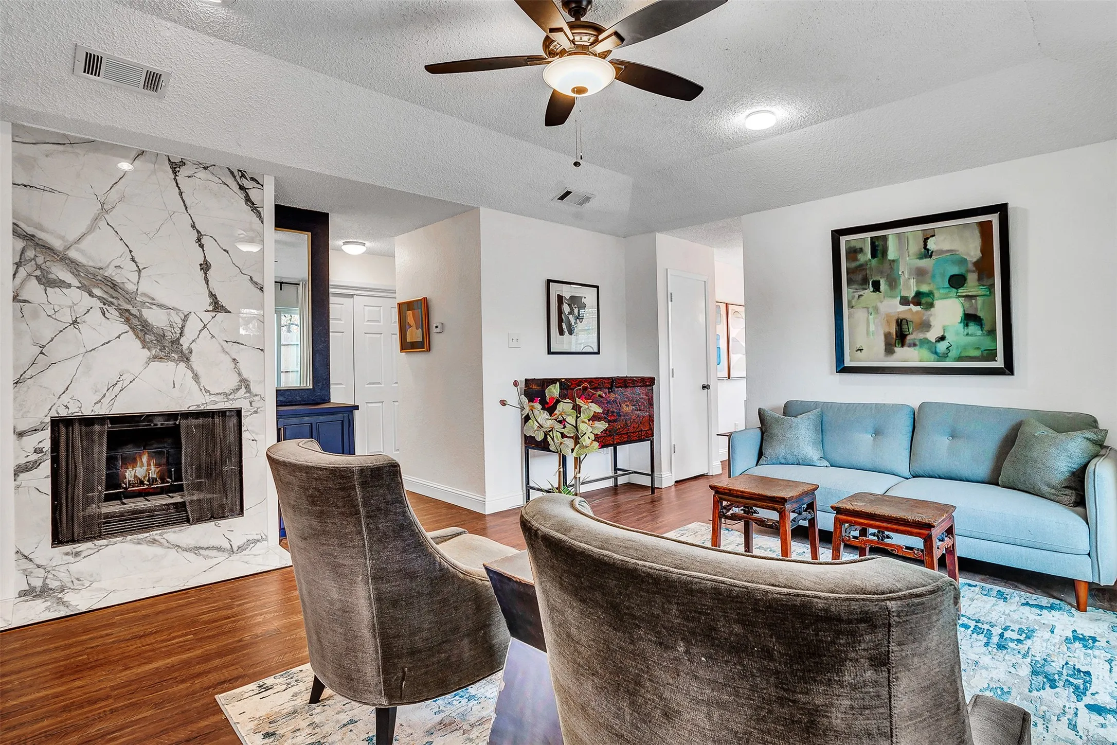 Wood-finish flooring, white walls, and a recessed ceiling with a ceiling fan
