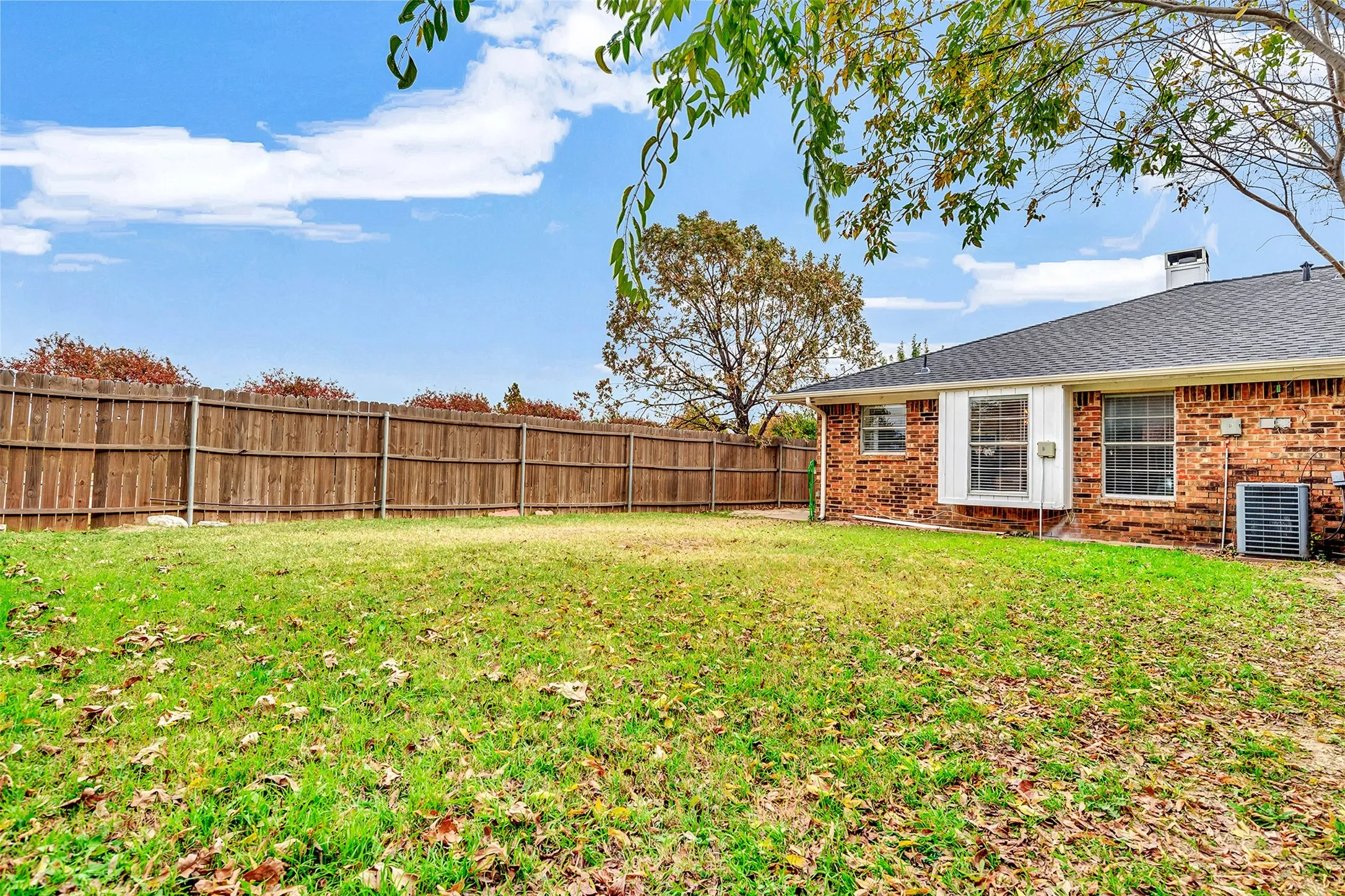 Expansive green space with a full privacy fence