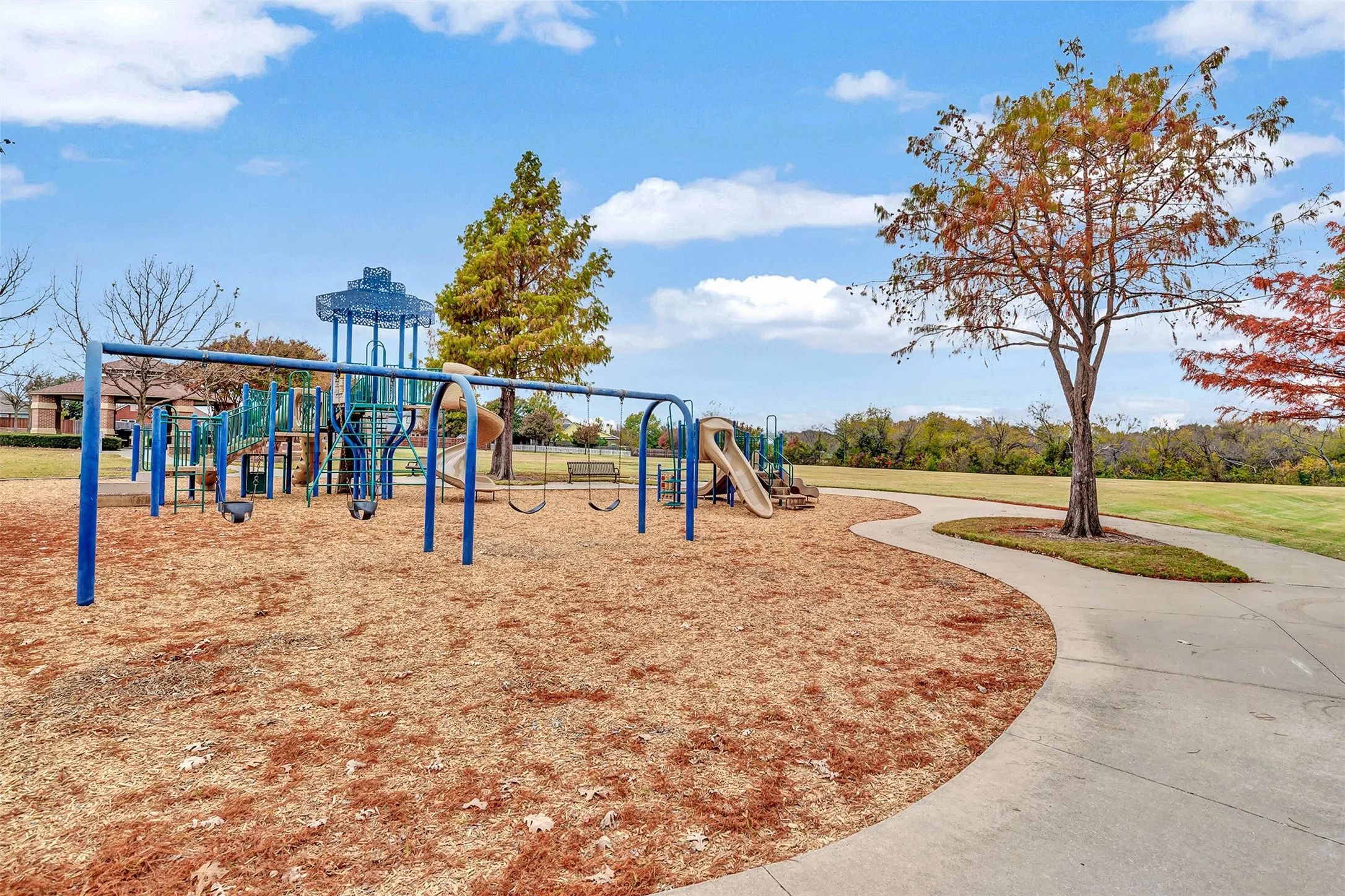 Community playground featuring multiple slides, swing sets, and climbing structures