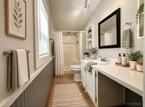 Modern vanity with integrated sink, extensive countertop space, white cabinetry, and a black-framed mirror
