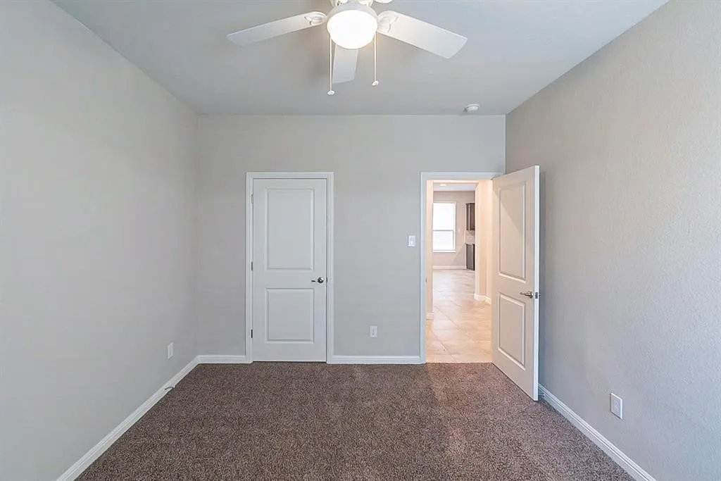 Unfurnished bedroom featuring carpet floors, ceiling fan, and baseboards