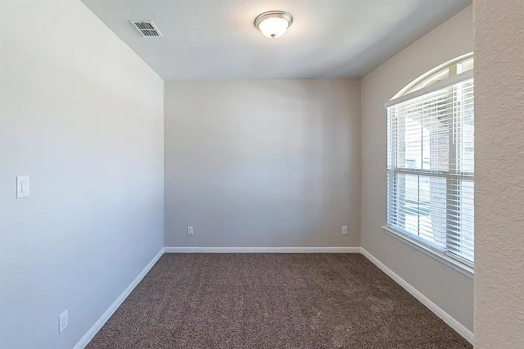 Spare room featuring baseboards, visible vents, and carpet flooring