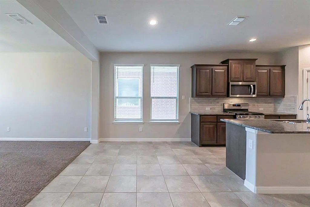 Kitchen featuring appliances with stainless steel finishes, a sink, visible vents, and tasteful backsplash