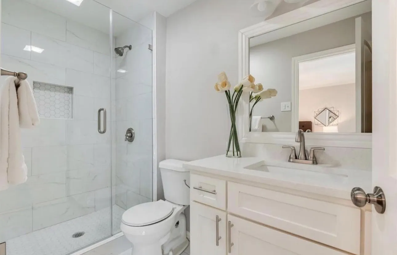 Glass-enclosed shower with subway tile surround and hexagonal tile accent niche