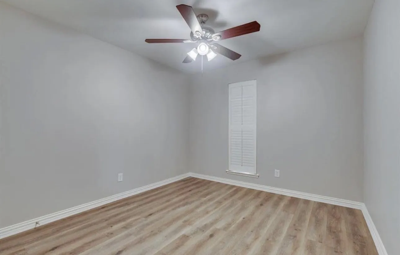 Wood-finish flooring, ceiling fan with integrated lighting, window with plantation shutters