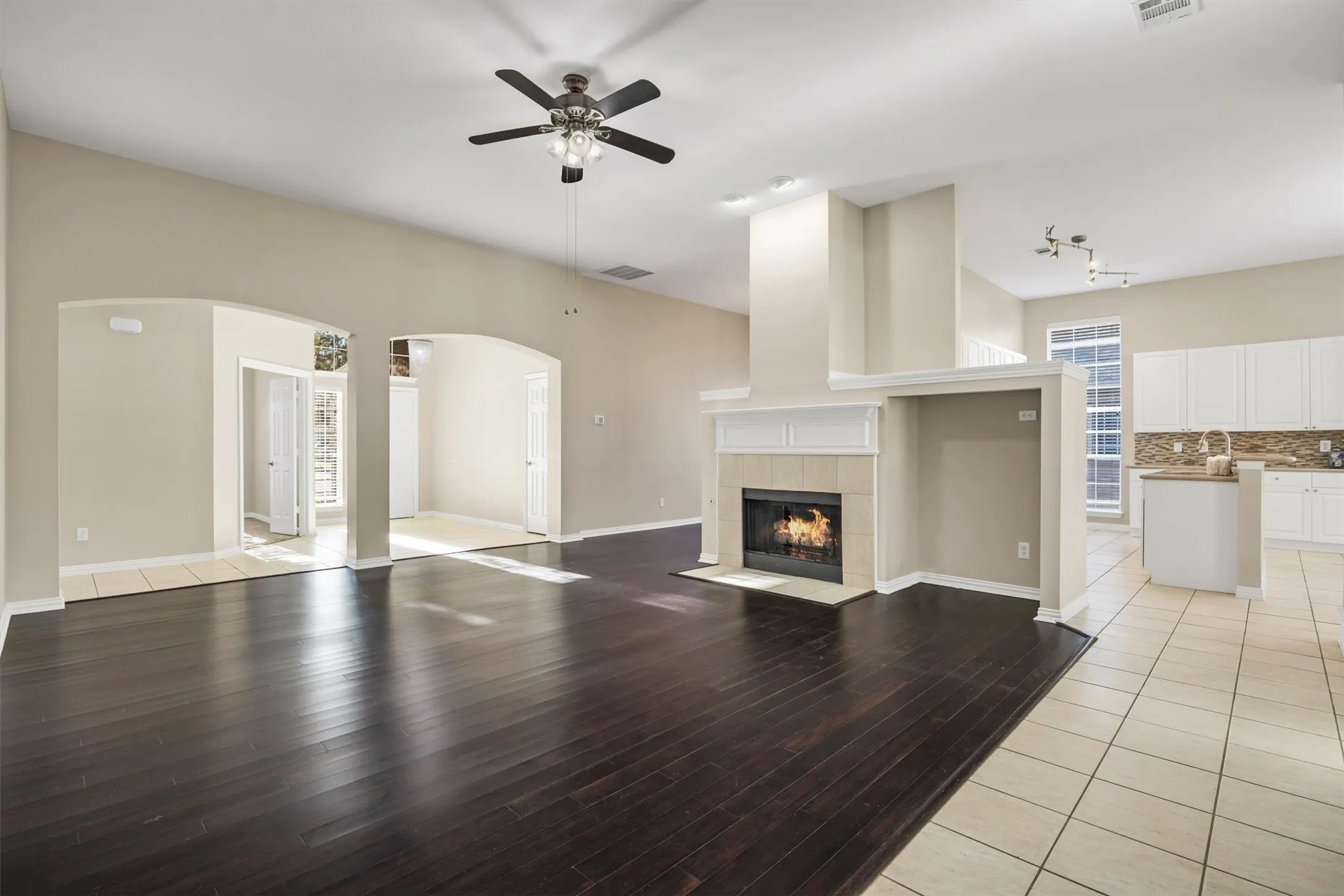 Vaulted ceiling, arched doorways, kitchen and dining room around the centered fireplace