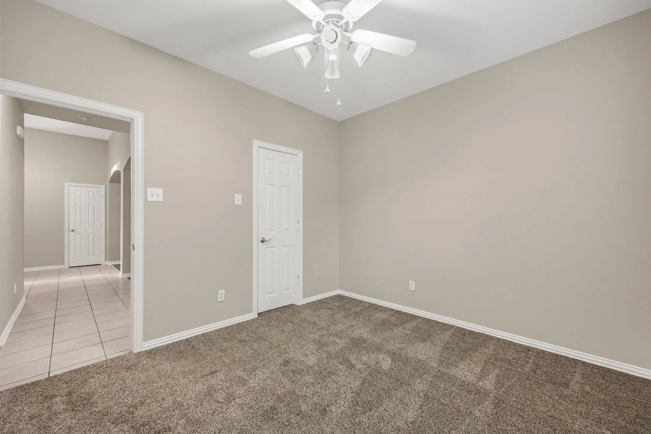 Bedroom 2 with carpet flooring, ceiling fan, and walk in closed.
