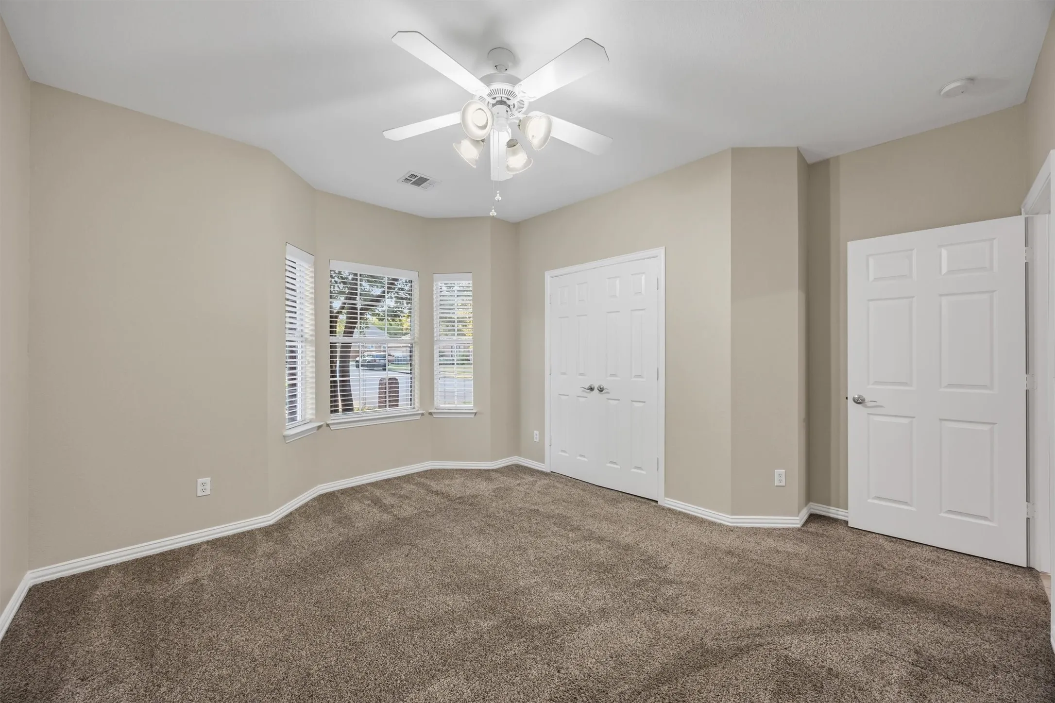 Bedroom 3 with Bay window, ceiling fan, carpet flooring, and double door closet