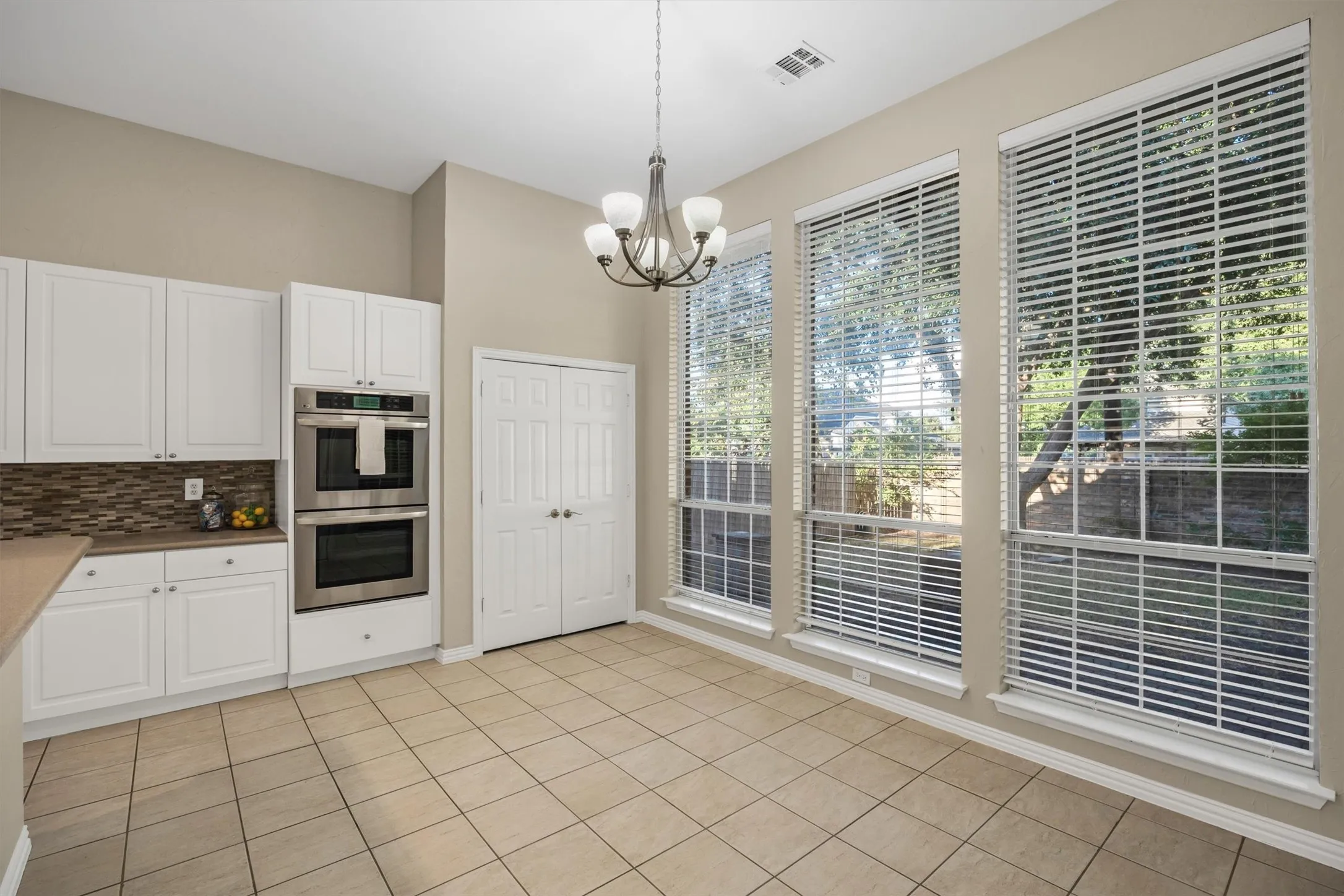 Breakfast dining area, SS double ovens, mosaic tile backsplash, and large windows