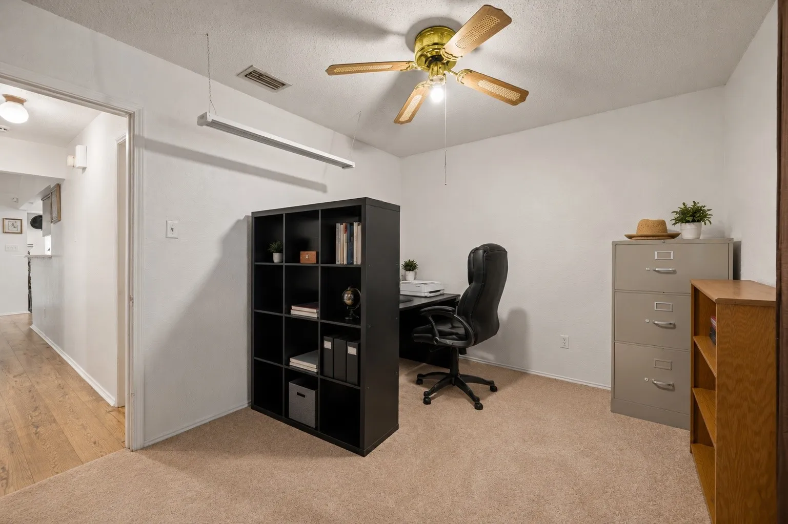 Carpeted flooring, ceiling fan with light fixture, and white wall finishes