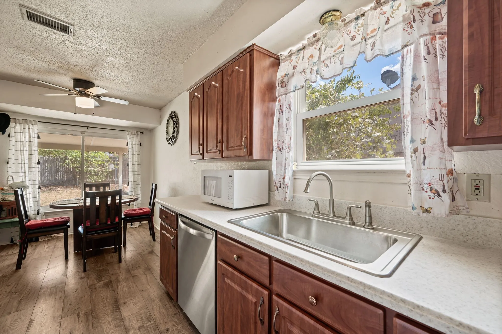 Kitchen featuring wood-finish flooring, cherry wood cabinetry, and a stainless steel sink