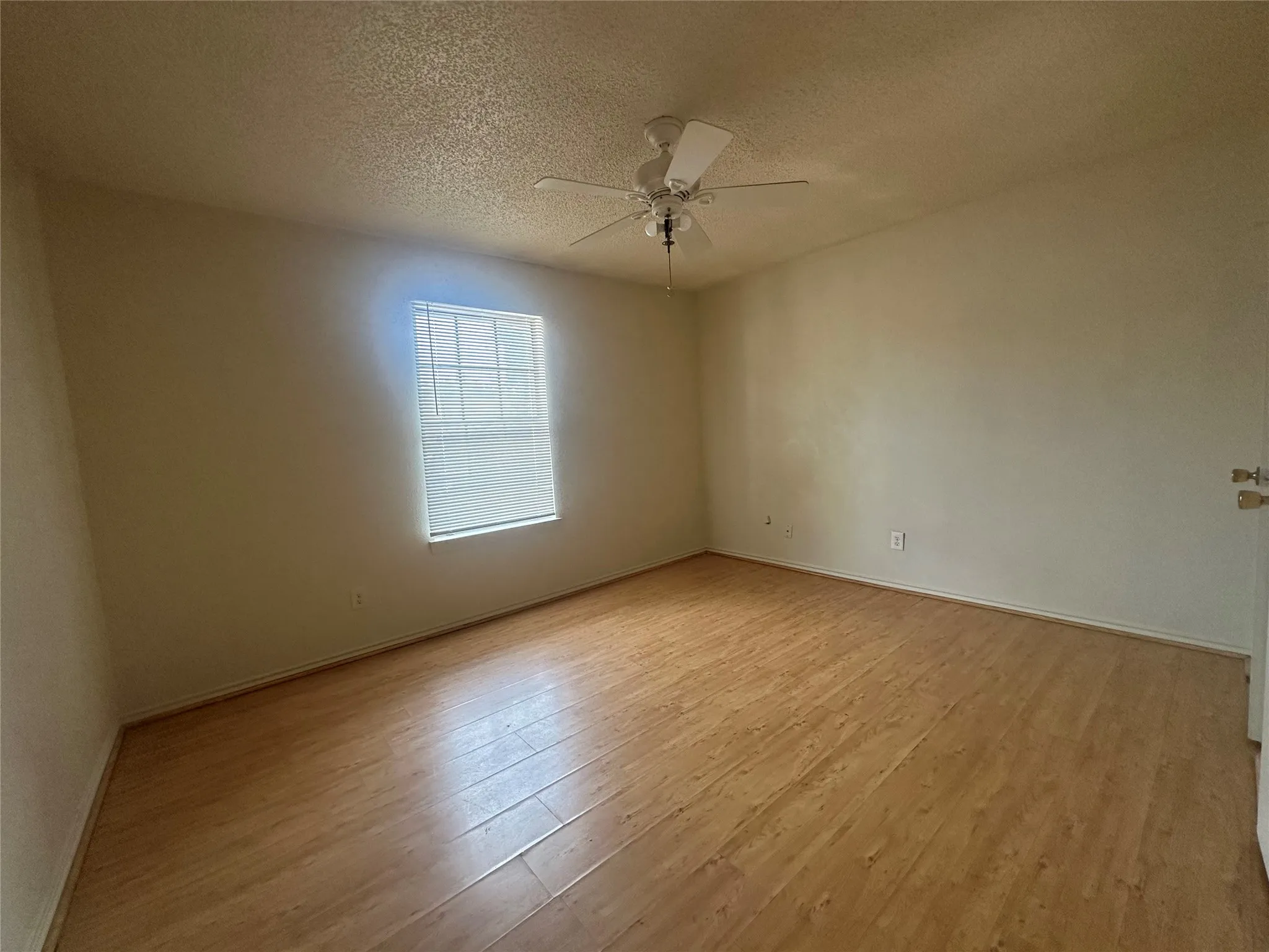 Wood-finish flooring, single window, and ceiling fan with integrated lighting