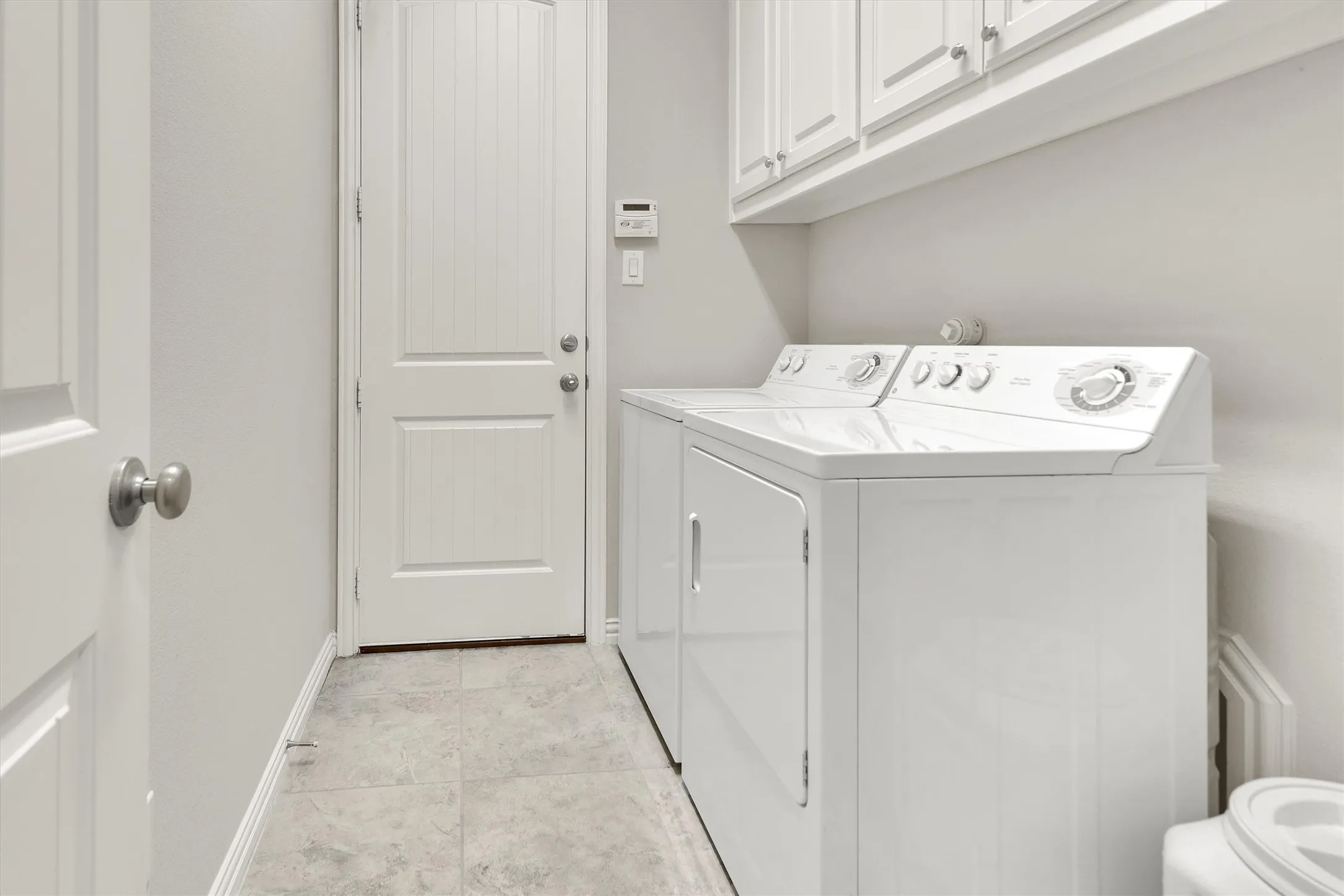 Built-in cabinetry, overhead storage, and tile flooring